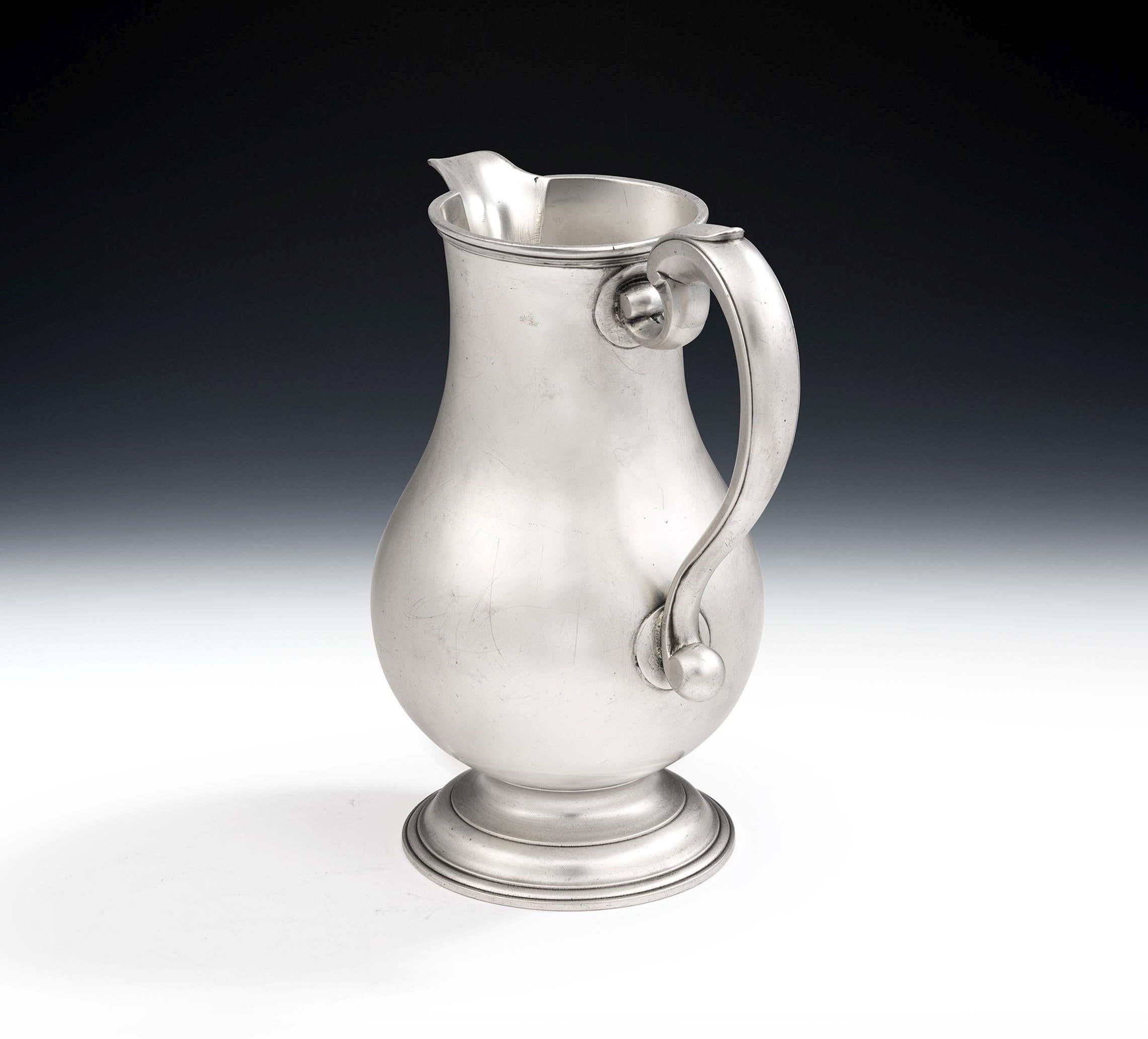 An Extremely Fine George II Beer Jug Made in London in 1750 by Thomas Whipham I.

The Jug stands on a cast and applied stepped circular foot which is decorated with reeding.  The pear shaped main body rises to a slender neck which is also decorated