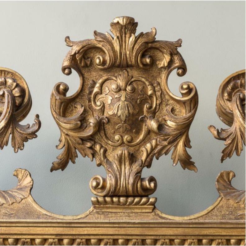 A rare and magnificent period example, a mid 18th Century overmantel mirror with swan neck and broken pediment, centred by a scrolling foliate cartouche above shell & ancathus decorated frieze. 

Entirely in carved giltwood, it makes an incredible