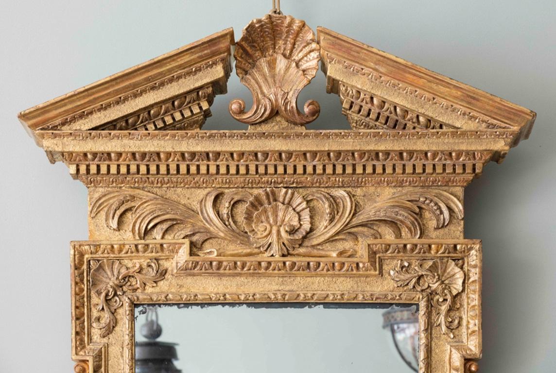 Miroir d'embarcadère en bois doré sculpté de forme palladienne, de style George II, avec un fronton en arc brisé à moulures en forme d'œuf et de dard, centré par une coquille, au-dessus d'une frise en volutes de feuilles, avec une plaque
