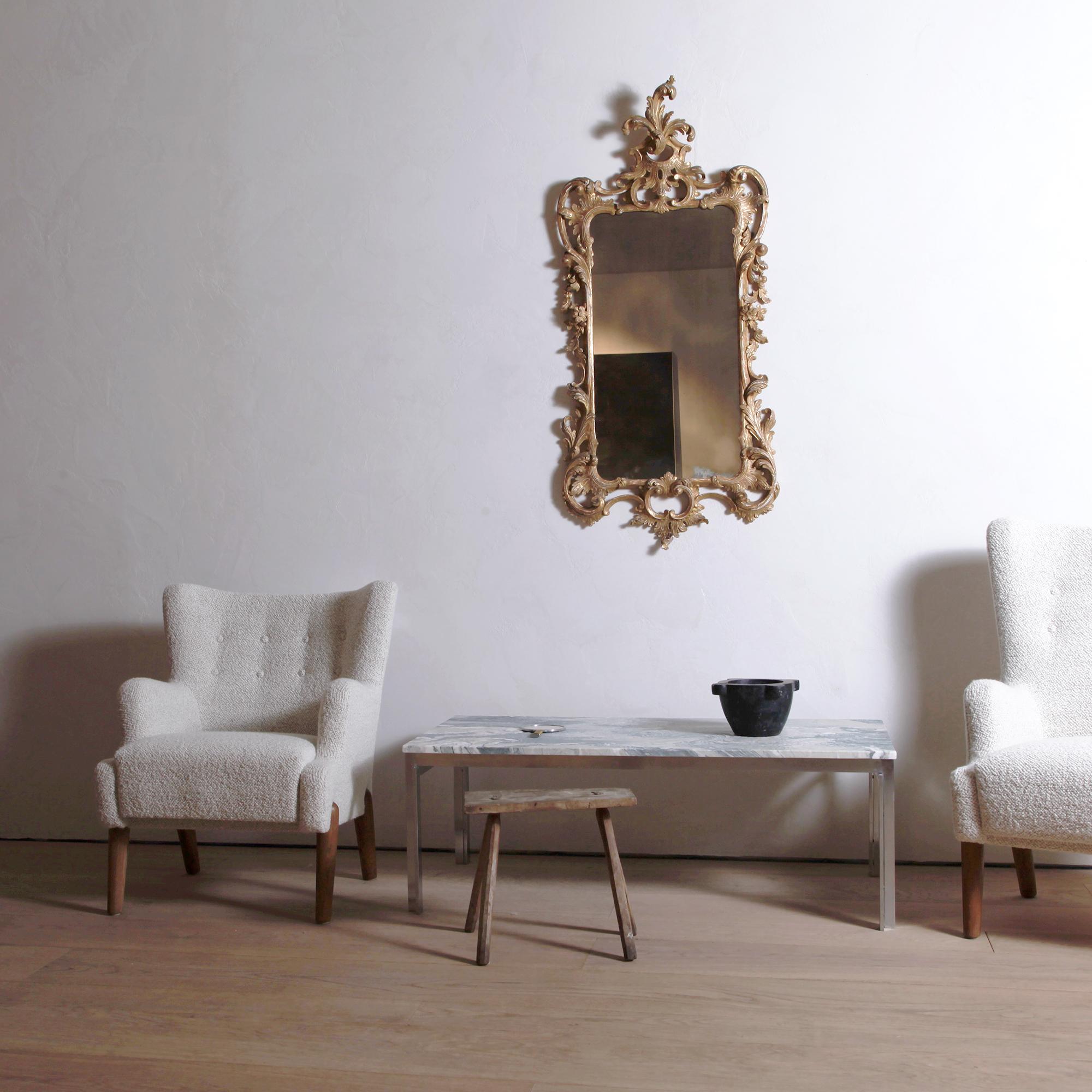 Avec ses rinceaux, sa dorure usée par le temps et sa plaque de miroir antique, cet exemple est une note de grâce bienvenue dans un décor luxueux. En très bon état vintage avec une plaque de miroir plus ancienne.