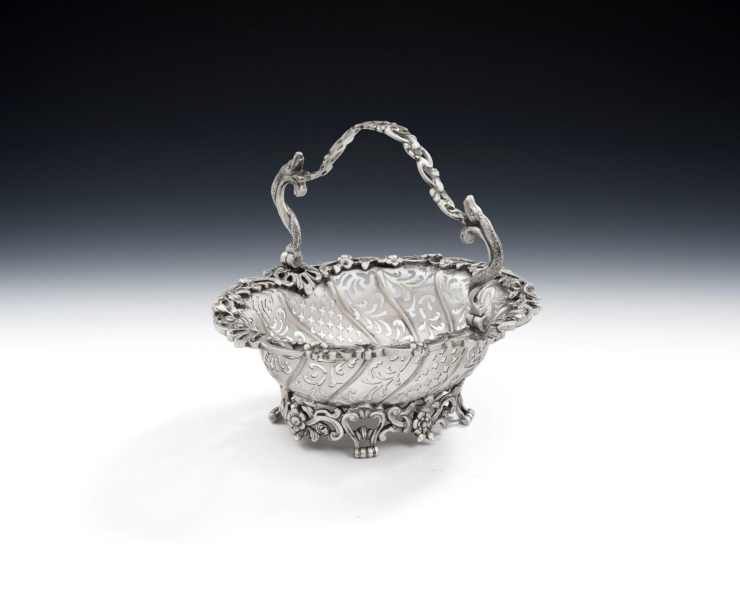 An Exceptionally Fine & Unusual George II Cast Sweetmeat Basket Made in London in 1758 by William Plummer

The basket is cast and stands on an openwork base decorated with scrolls and raying flower heads, together with four unusual stylised lyre