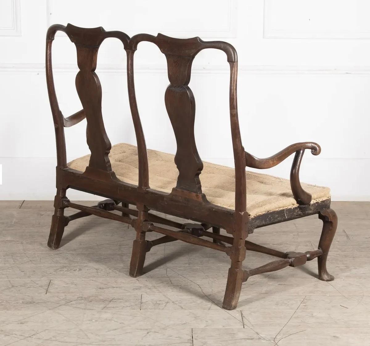 Ce canapé à dossier de chaise du milieu du XVIIIe siècle, d'époque George II, est une remarquable représentation de l'artisanat raffiné. Construit en noyer et en chêne, il présente un dossier unique et des silhouettes élégantes qui incarnent la