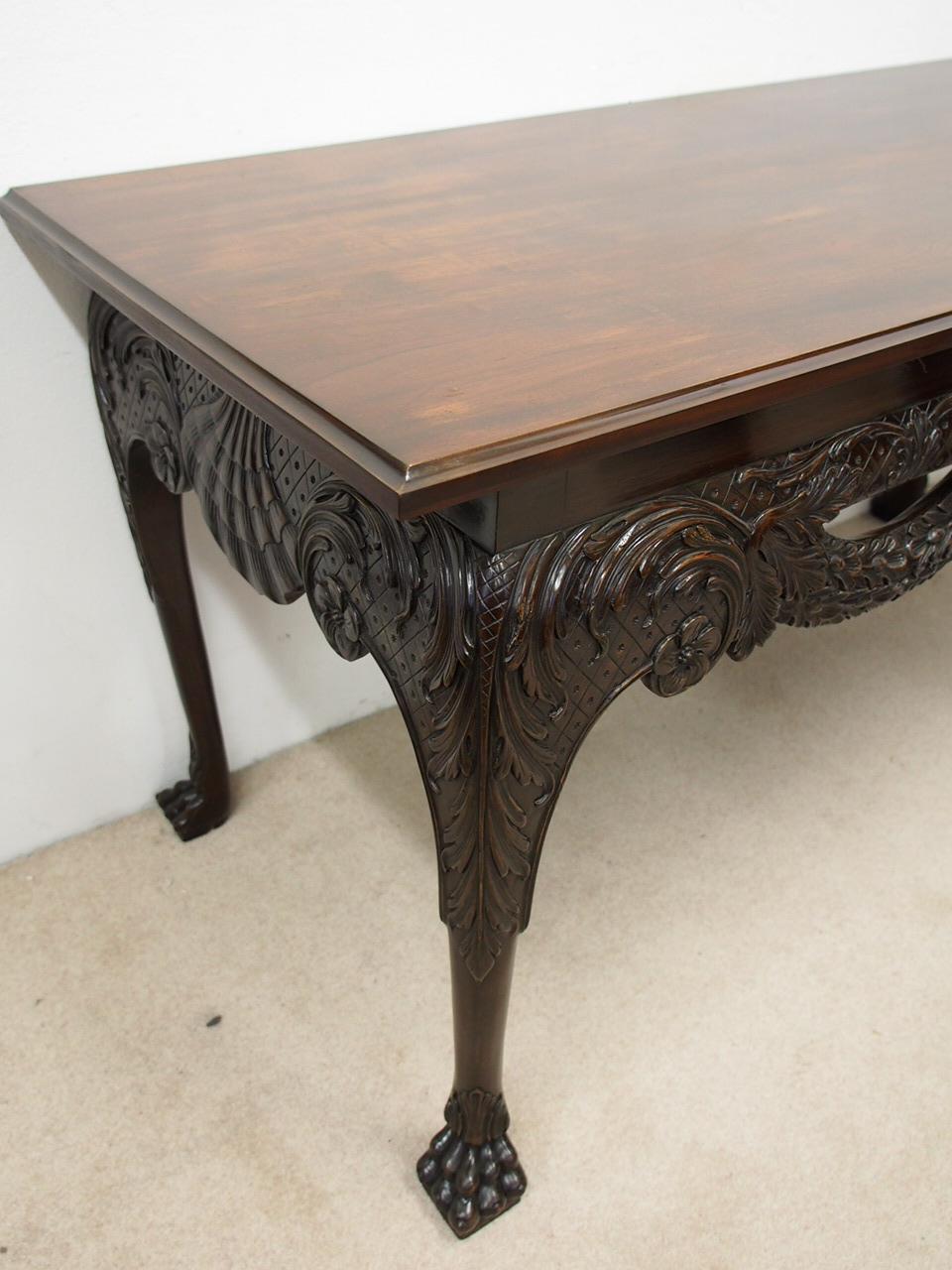 Mid 1800s, Irish George II Chippendale style carved mahogany hall table. The rectangular mahogany top with a fluted molding (originally would have had a marble top) is over an impressive carved frieze on both sides and front. It contains a central,