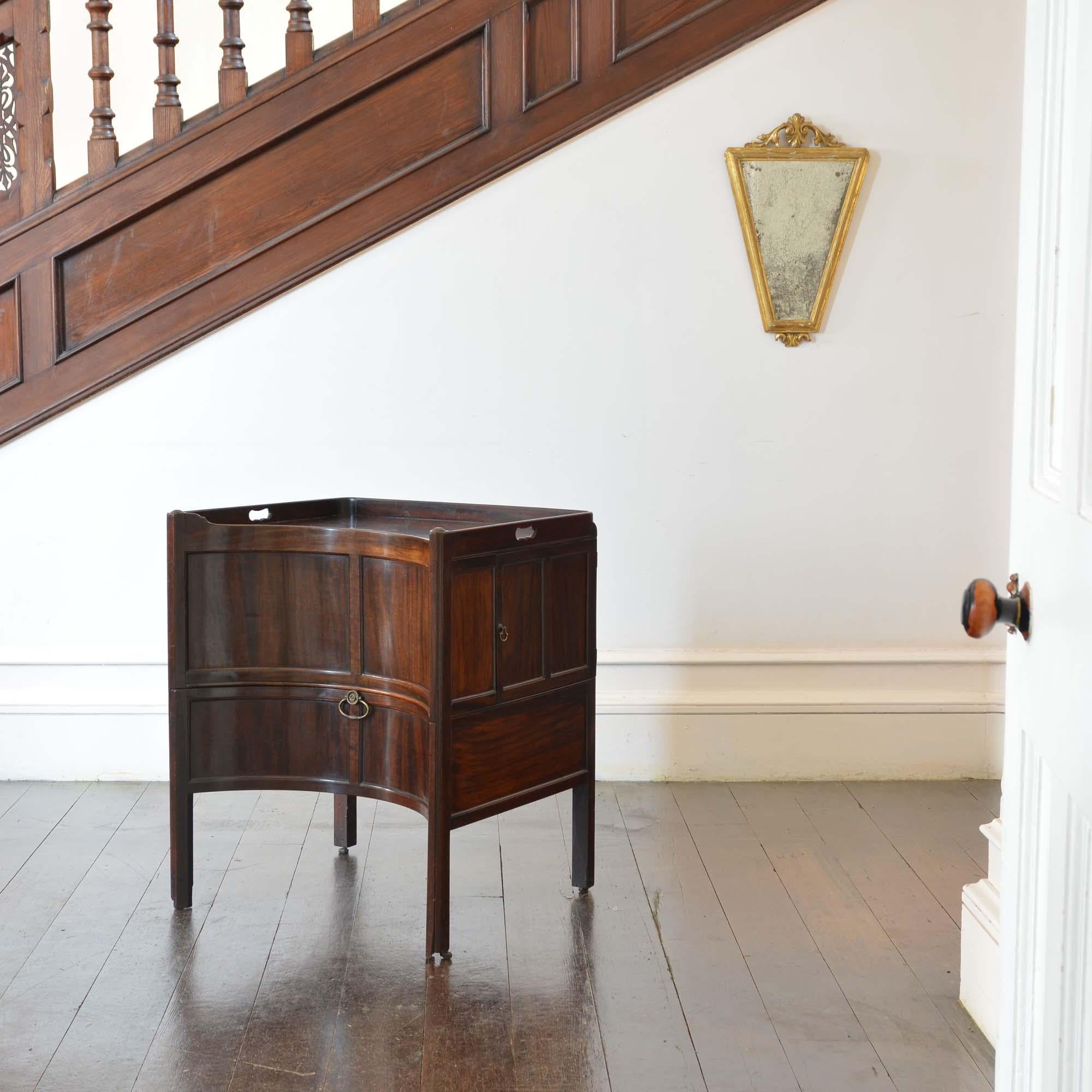 George II concave mahogany commode

An exceptional Georgian mahogany tray-top commode of unusually large scale and quality.  The raised gallery pierced to the sides to form a pair of handles, the front of deep concave form with panelled front and