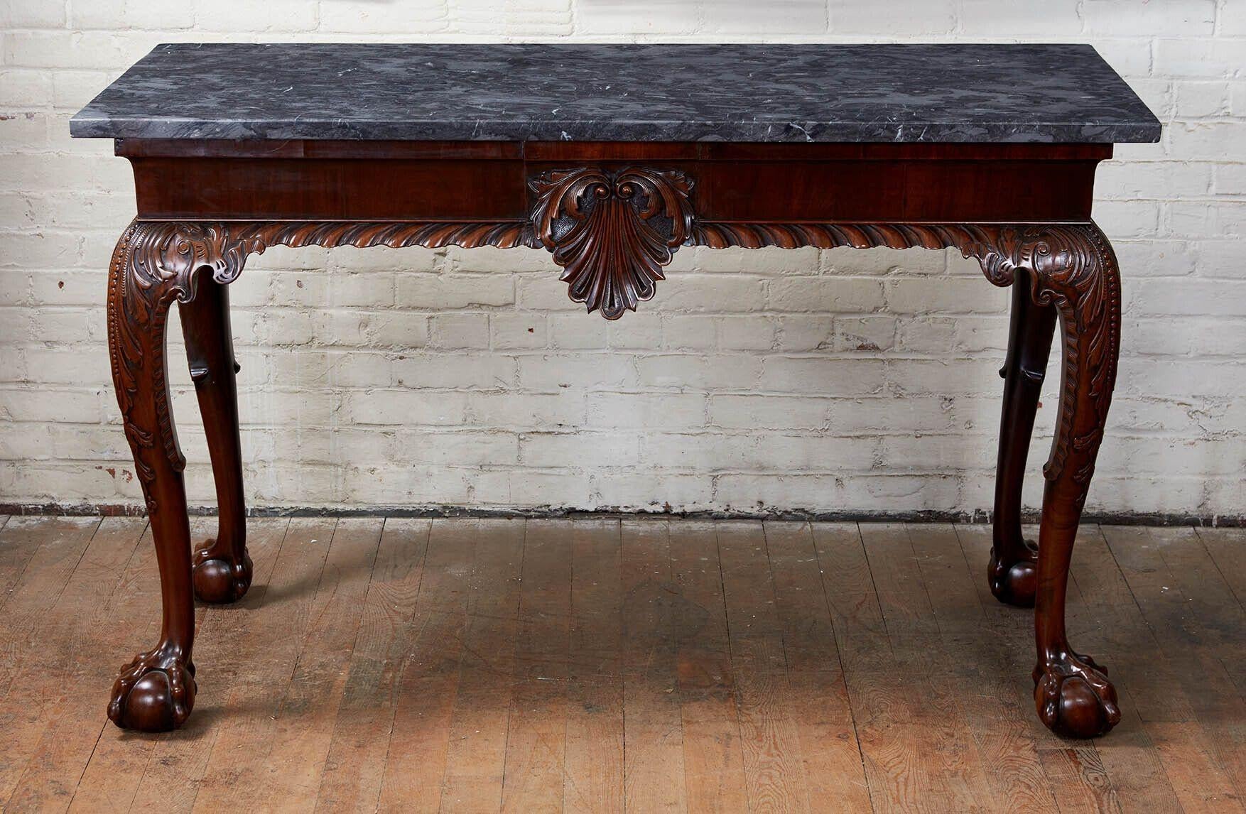 Very fine George II marble top console table, the later grey stone top over molded apron, the front with carved shell over richly gadrooned edge, the boldly formed cabriole legs having foliate carving and acanthus carved knees, ending in pronounced