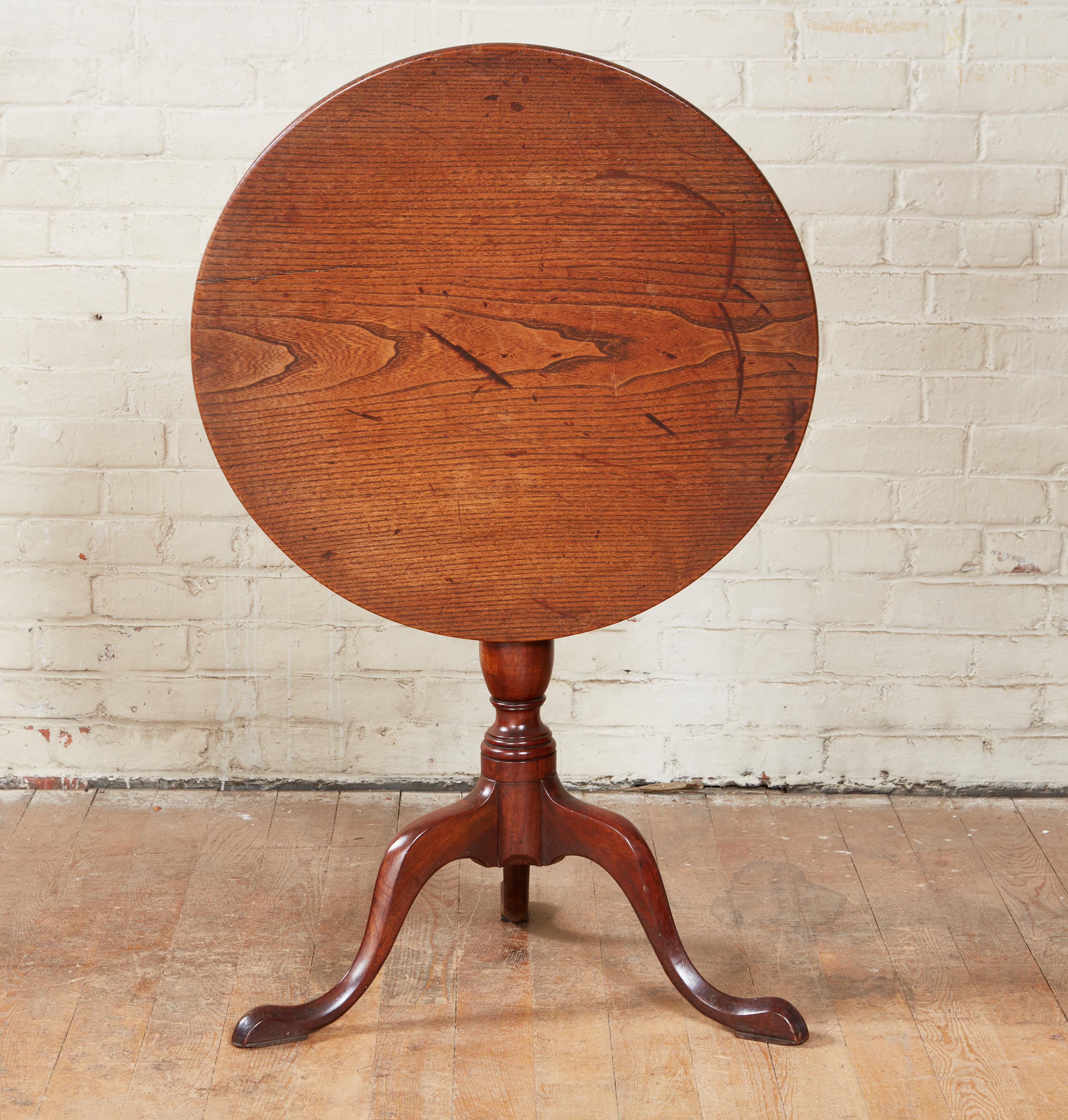 Good 18th century English country tilt top tripod table having single plank elm top over balustrade turned stem standing on shapely slipper feet, the whole with pleasing old surface and patina and retaining original blacksmith made iron latch.