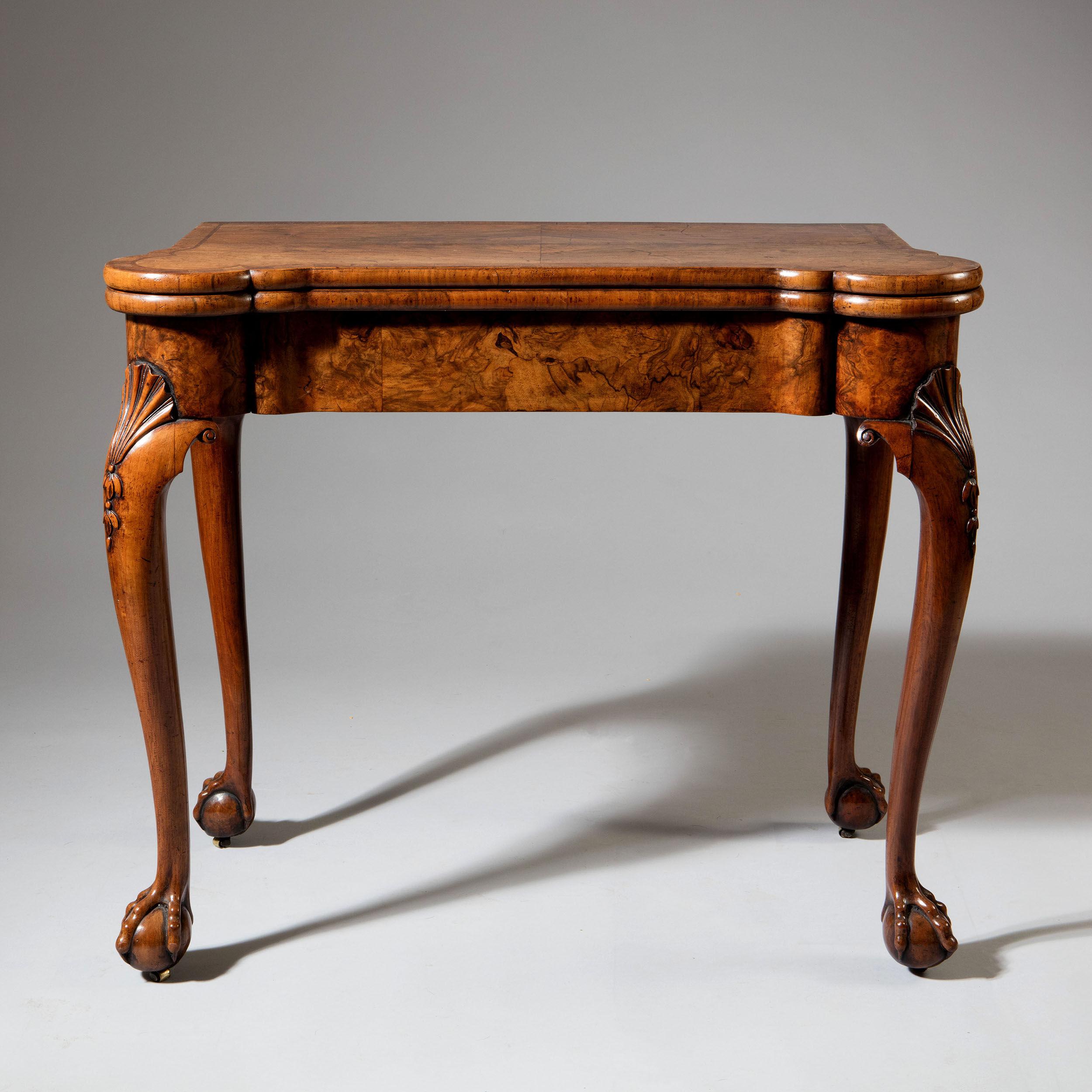 This superb figured walnut games table has trefoil style corners to the fronts and is elegantly raised on carved cabriole legs, terminating on carved ball and claw feet, witch retain there original leather bound caters. To the centre of the table