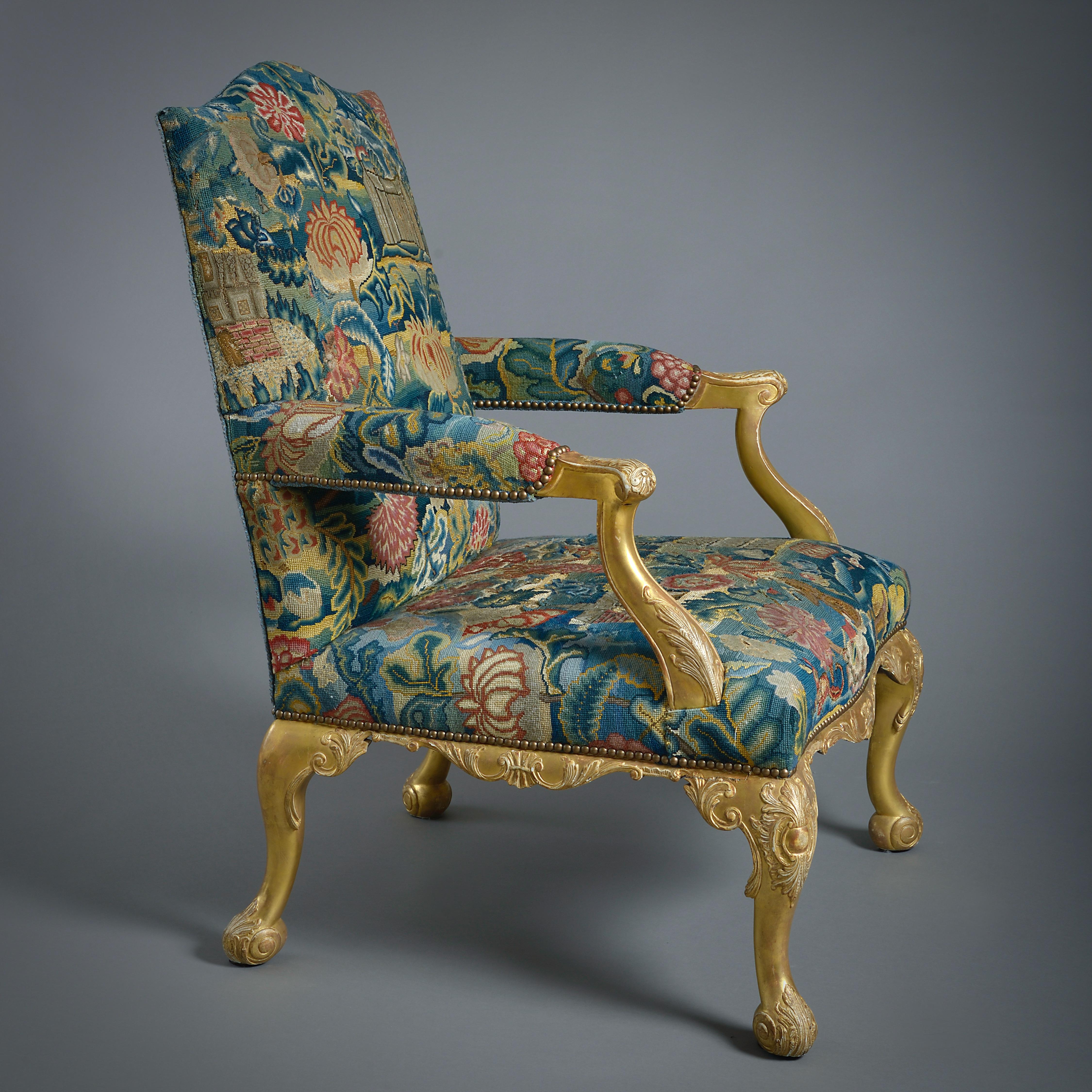 A FINE GEORGE II GILTWOOD LIBRARY CHAIR, UPHOLSTERED IN ASSOCIATED 18TH CENTURY NEEDLEWORK, Circa 1760.