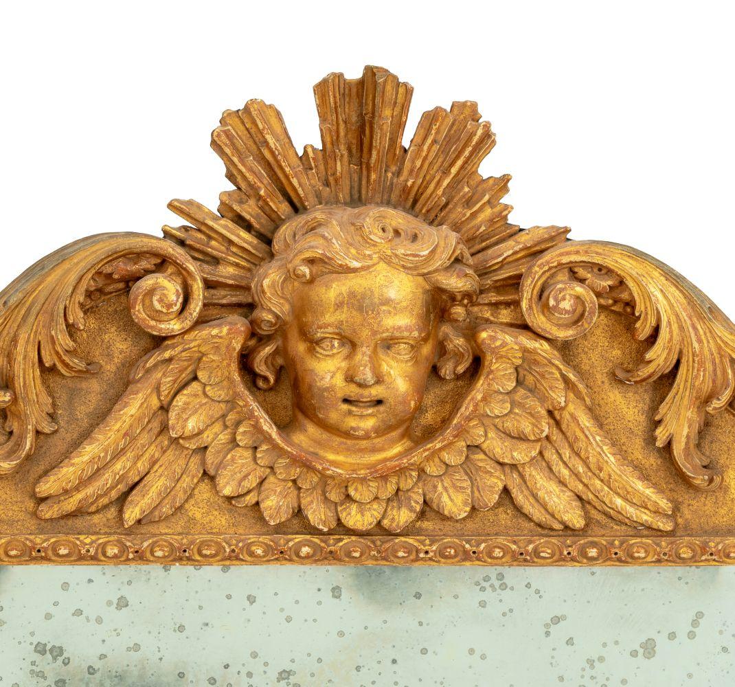 Pareja de espejos de muelle de madera dorada Jorge II, hacia 1740, a la manera de William Kent, cada uno de forma arquitectónica, las placas rectangulares biseladas dentro de un marco lijado, bordes moldurados y decoración tallada foliada, coronados
