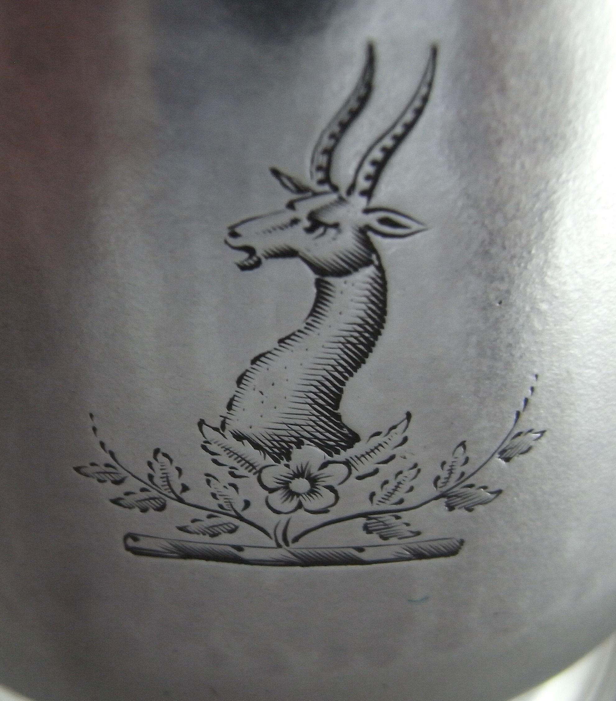 A Fine George II Half Pint Mug Made in London in 1758 by Thomas Moore

The Mug stands on a circular spreading foot decorated with reeding. The main body is baluster shaped in form, with an everted rim. This example has a plain scroll handle and the