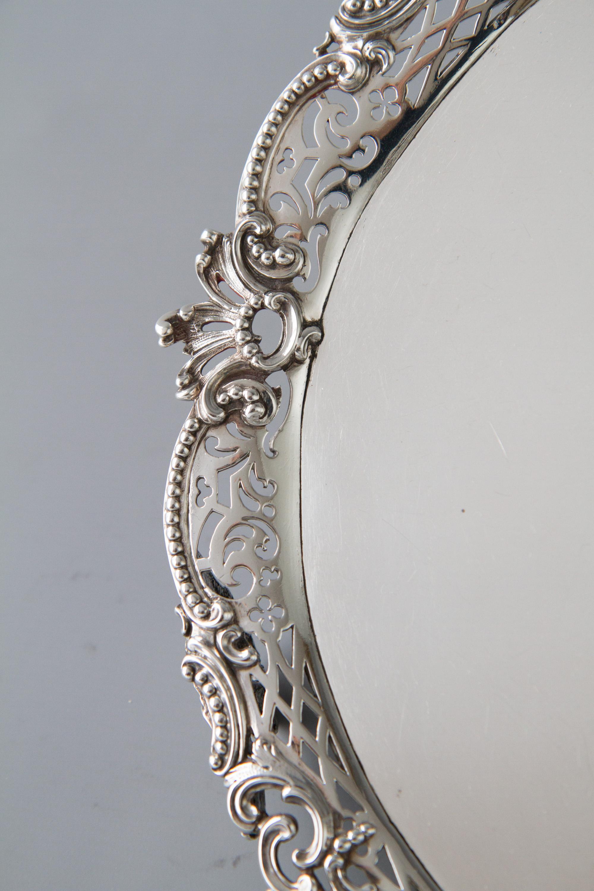 A rare and superb George II silver salver of shaped circular form flat sheet set into a cast floral and beaded scroll gallery. Standing on three openwork cast shell, scroll feet.

Hallmarked to the underside for London 1759 by Samuel Courtauld.