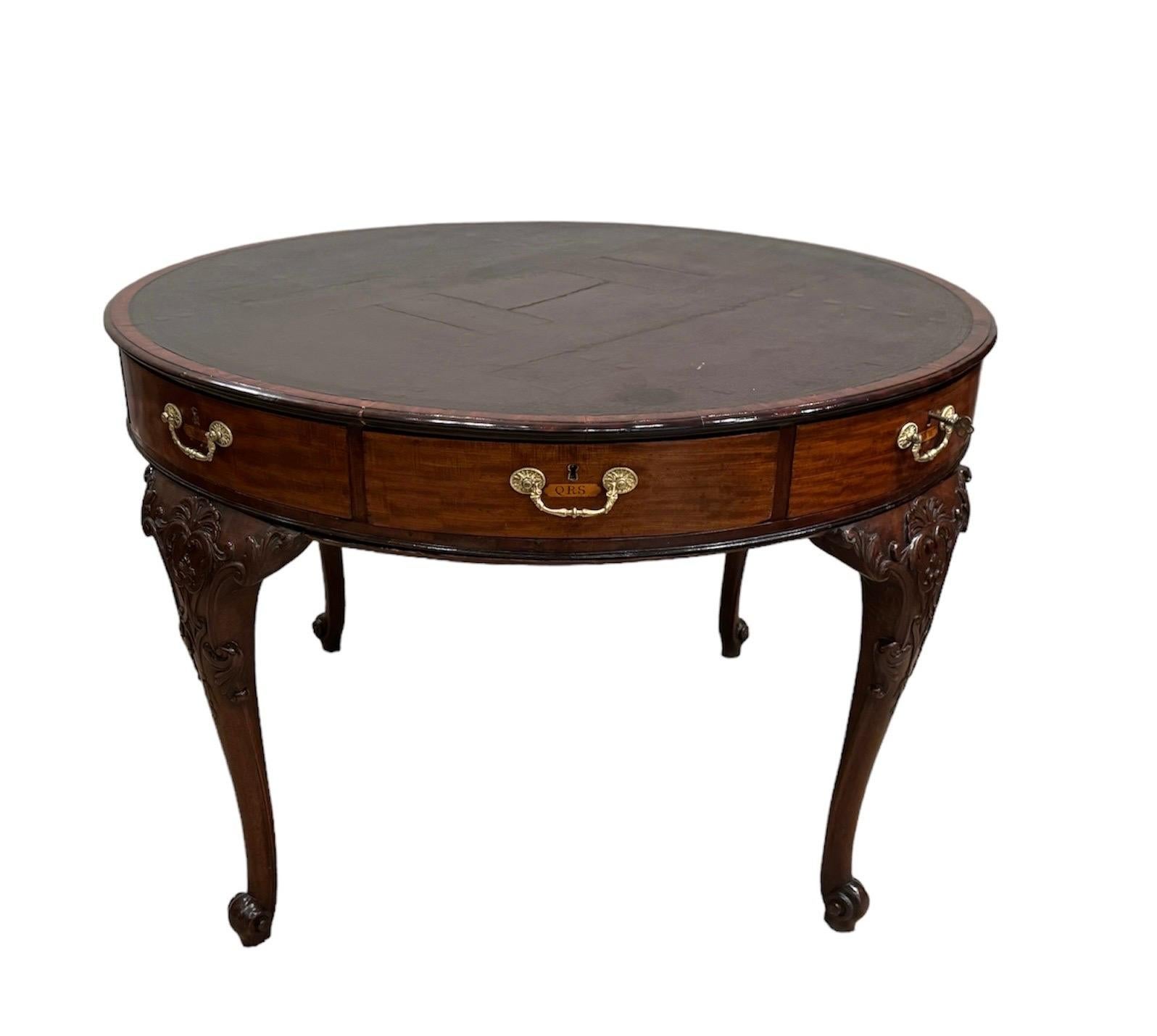 George II Mahogany Rent table with lettered inlaid drawer front & swiveling leather top ( see video) raised on carved cabriole legs terminating in carved scroll feet. with key
leather top has old cracks & imperfections that have been filled. In