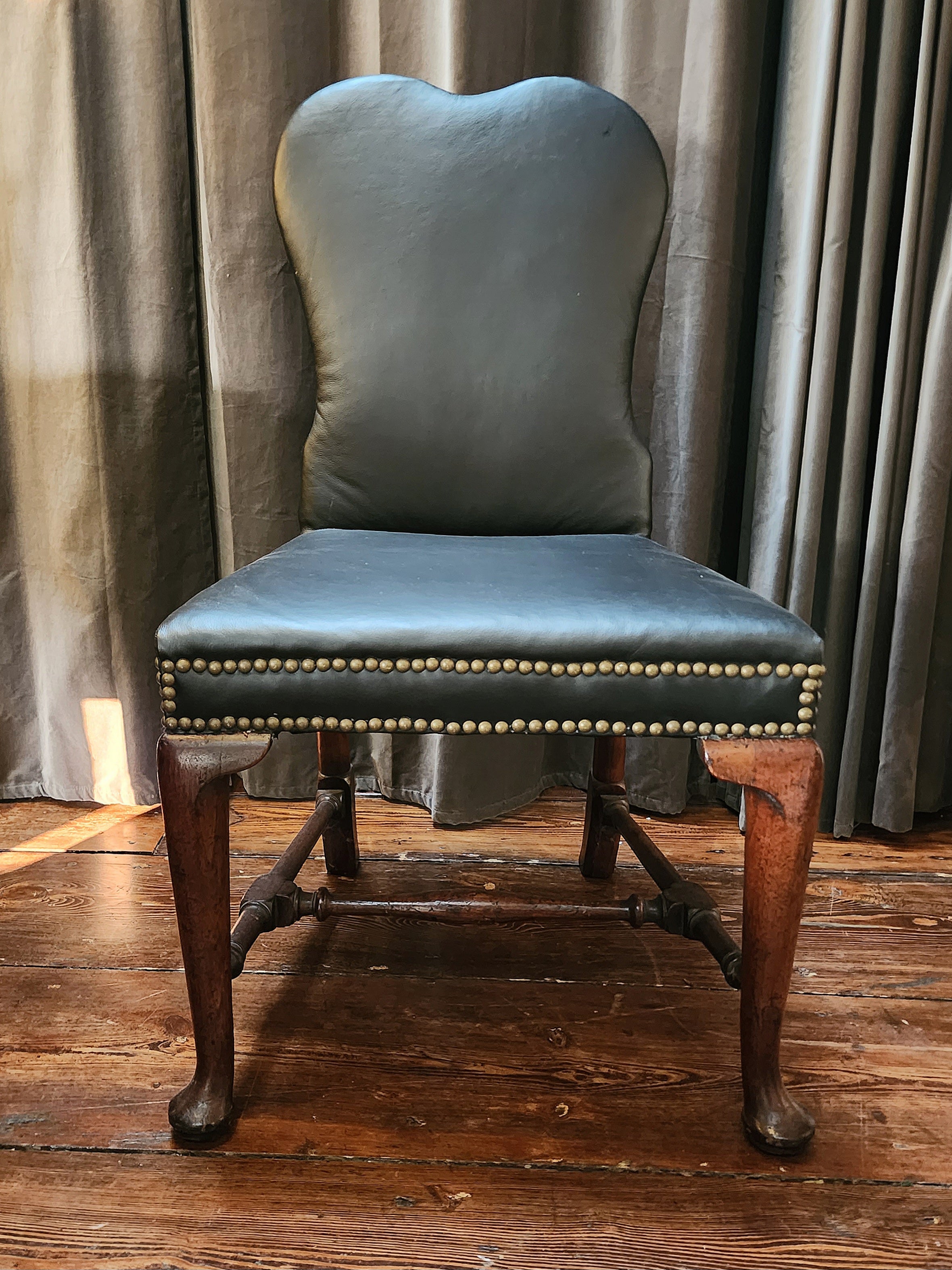 Beautiful and comfortable, this walnut upholstered chair with cabriole legs, yoked crest and delicate block and turned stretchers is 18th century elegance with a timeless modernity. 
Provenance: Purchased from an East Hampton Estate.

