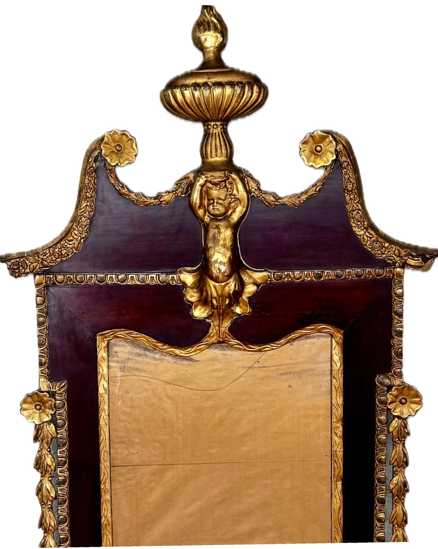 Splendido specchio in mogano dorato e gesso del XVIII secolo George II Parcel. Il piatto rettangolare è inserito in una cornice sagomata sormontata da un classico disegno a frontone spezzato con un rarissimo cherubino che regge un'urna fiammeggiante