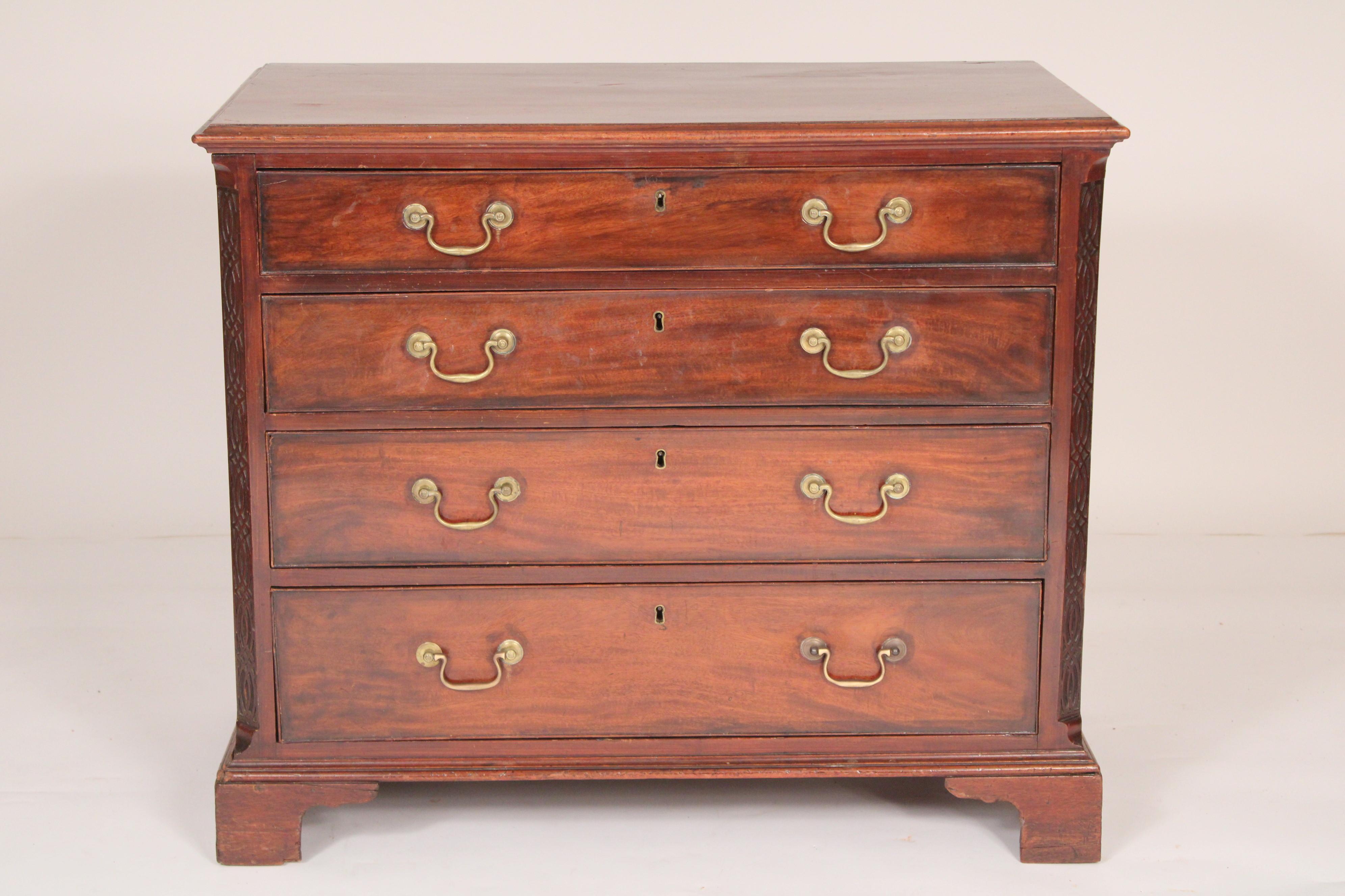 George II mahogany bachelors chest, 18th century. With a slightly over hanging rectangular top, the top drawer has a felt lined writing surface that slides back for storage, canted corners with Chinese blind fret carving, four graduated drawers