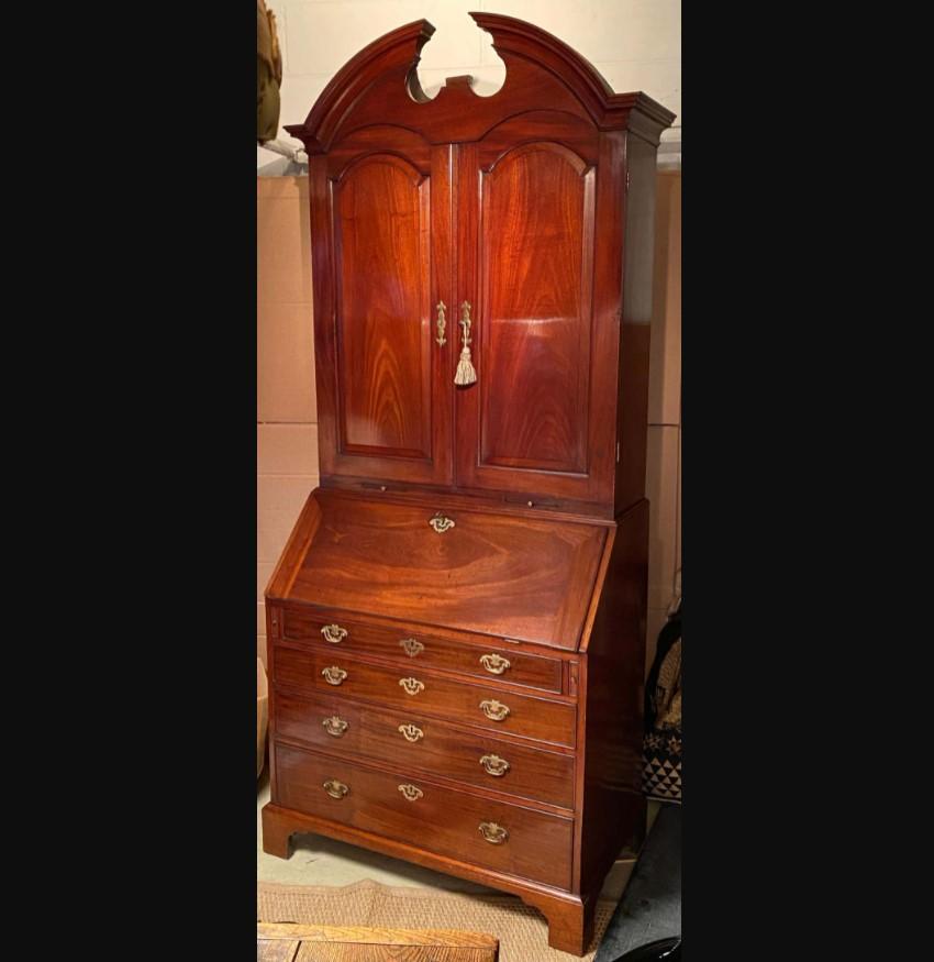 An 18th-century mahogany bureau cabinet of impressive architectural form and lovely rich color.
George II period, circa 1740. 

The top surmounted by a bold architectural pediment and centered by a brass finial. The two arched panel doors reveal