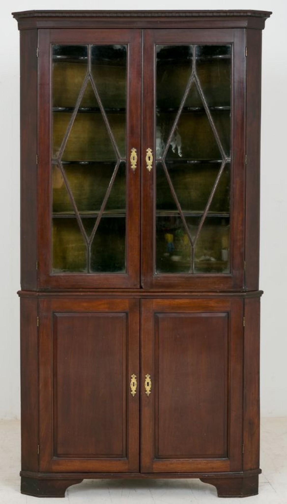 George II Mahogany Glazed Corner Cabinet.
circa 1750
Standing on bracket feet, featuring 2 fielded panel doors on the bottom section, the top section having a pair of astragal glazed doors revealing wonderful shaped shelves (typically early