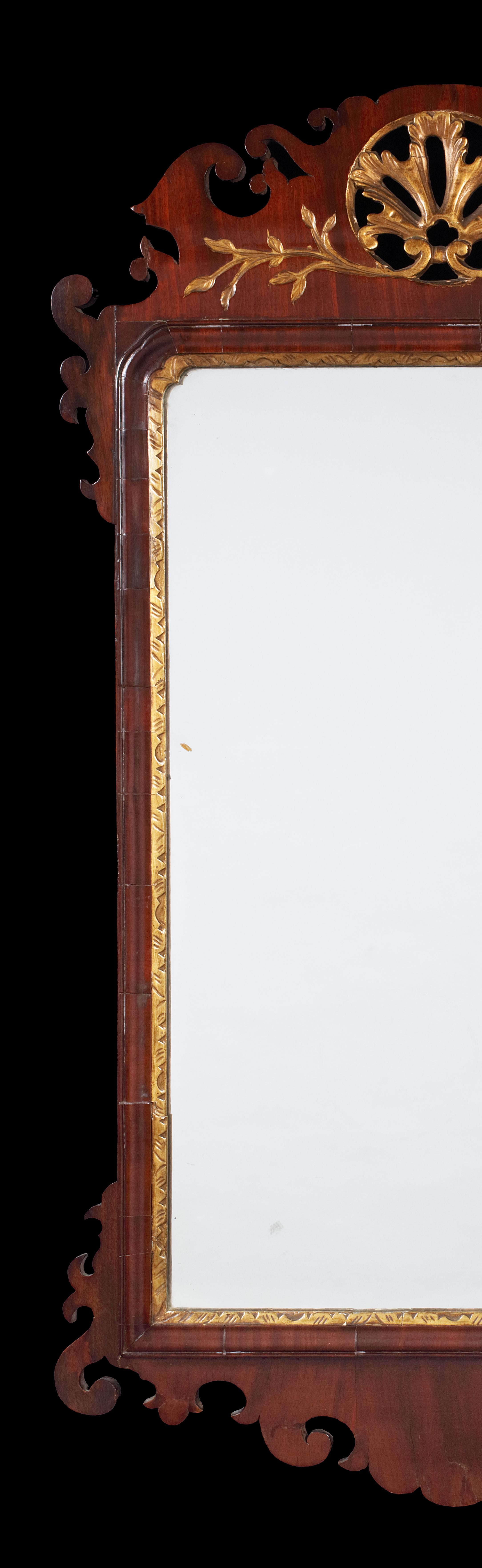 George II mahogany fret carved and parcel gilt mirror
The rectangular later plate within a leaf carved slip surmounted by a scrolling pierced acanthus leaf cresting with fret carved apron below, 114cm high, 63cm wide.