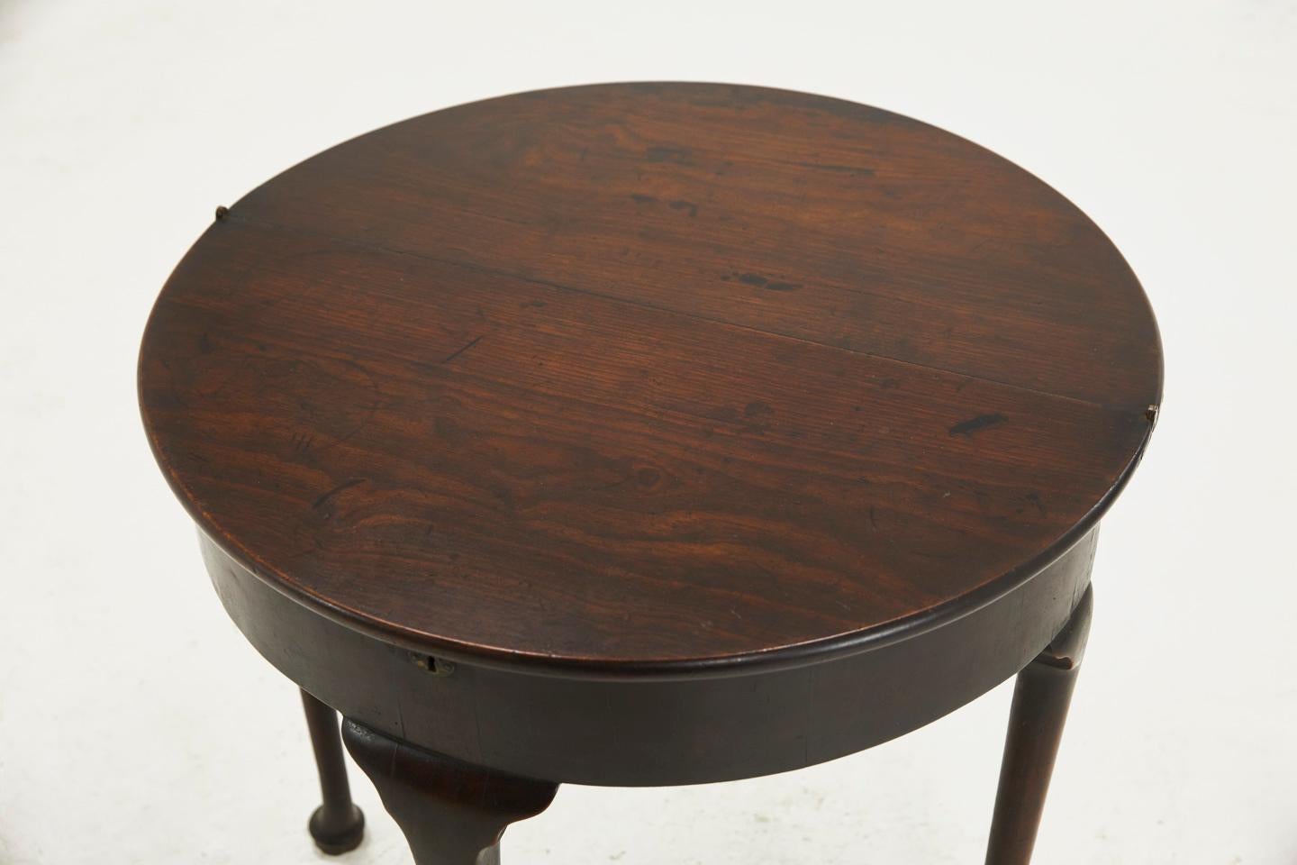 A small proportioned George II mahogany pad-foot half round, fold over top, tea table. Hard to find with such exceptional color and patina, circa 1740.