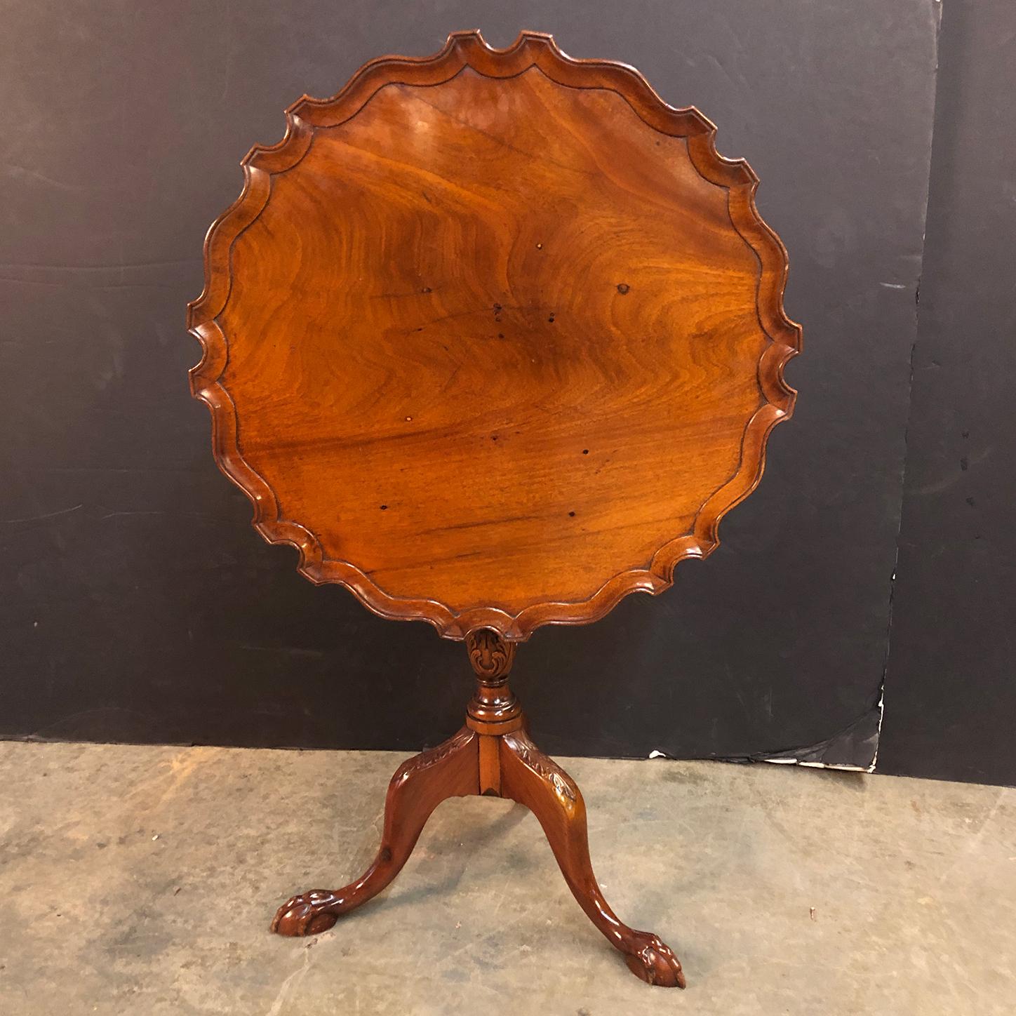A fine George II mahogany carved tilt-top pie crust side table with a birdcage for support, turned pedestal acanthus carved base with cabriole legs and ball and claw feet.