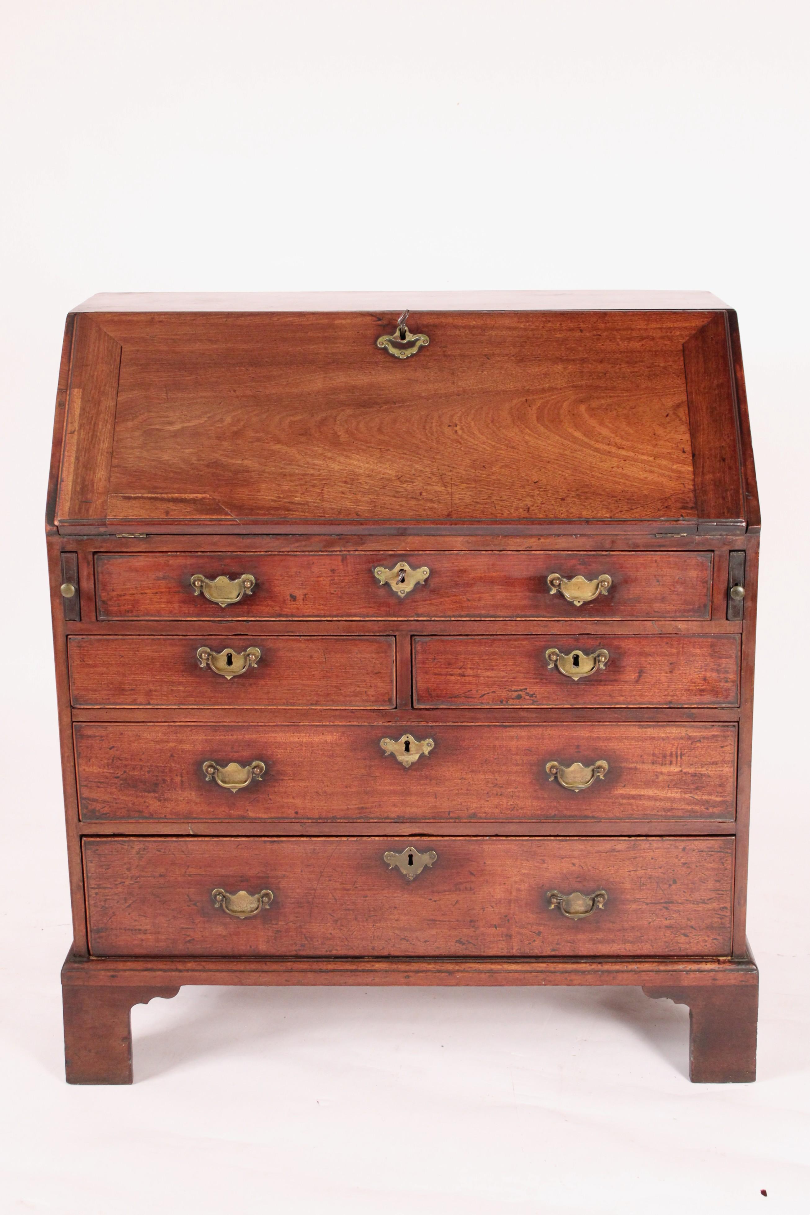 Bureau à plateau incliné en acajou, George II, 18e siècle. Avec un plateau rectangulaire à une planche, une façade à une planche, un intérieur avec des fentes pour les lettres et des tiroirs avec une porte centrale flanquée de colonnes cannelées, il