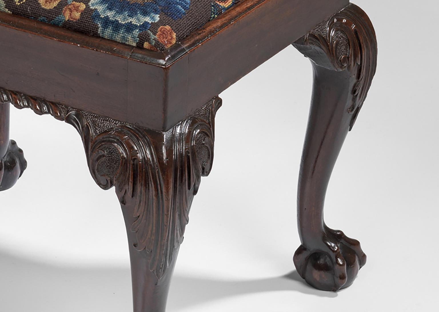 Upholstered with associated 18th century Petit Point & Cross Stitch Needlework.
A single mid-18th century mahogany stool with drop-in frame; a back and front gadrooned edge; upholstered in associated 18th century floral needlework; on cabriole legs