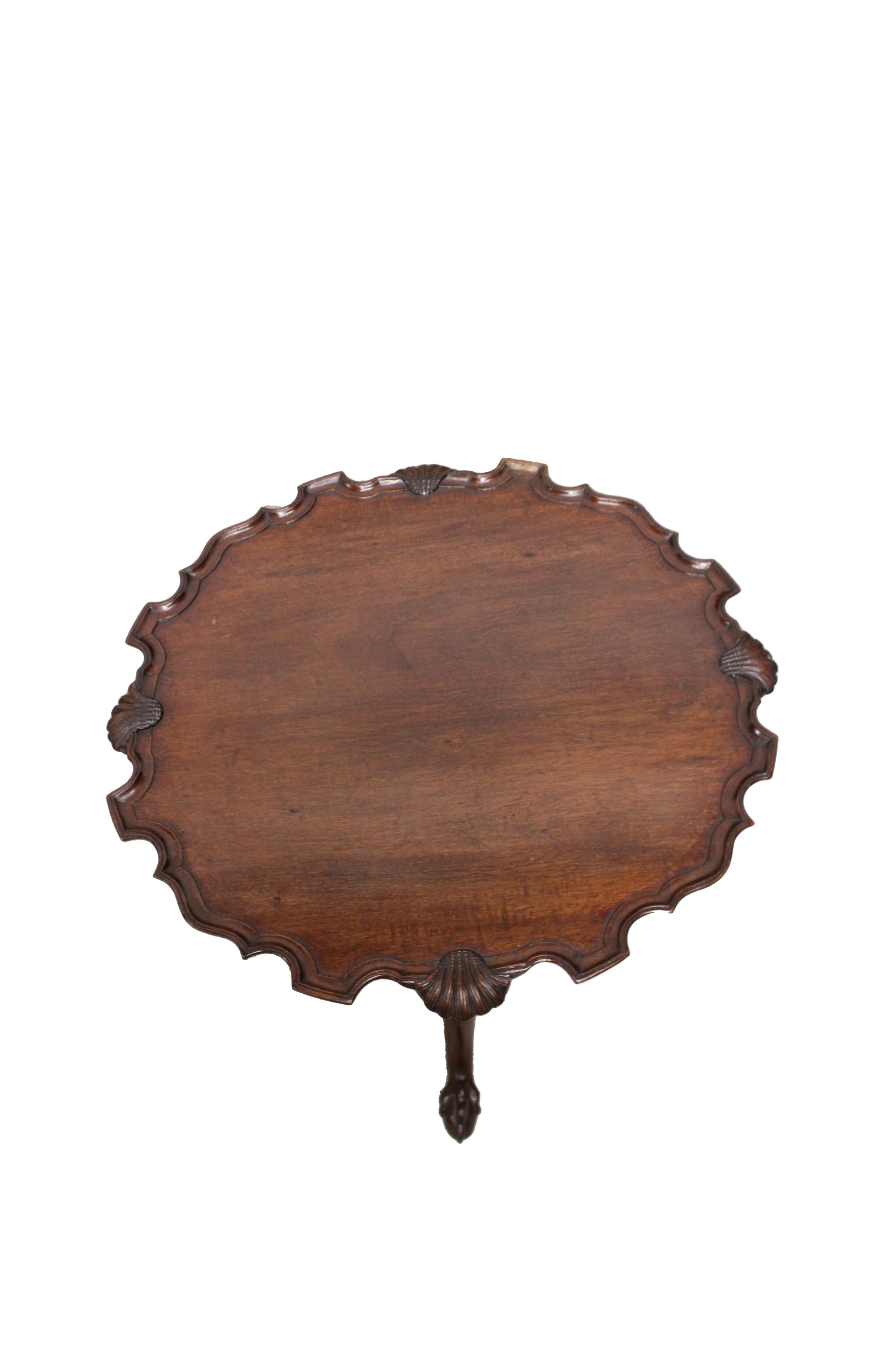 George II mahogany tilt-top tea table with beautiful shell carving and baluster support standing on three cabriole legs. Circa 1727-1760. Slight condensation damage.