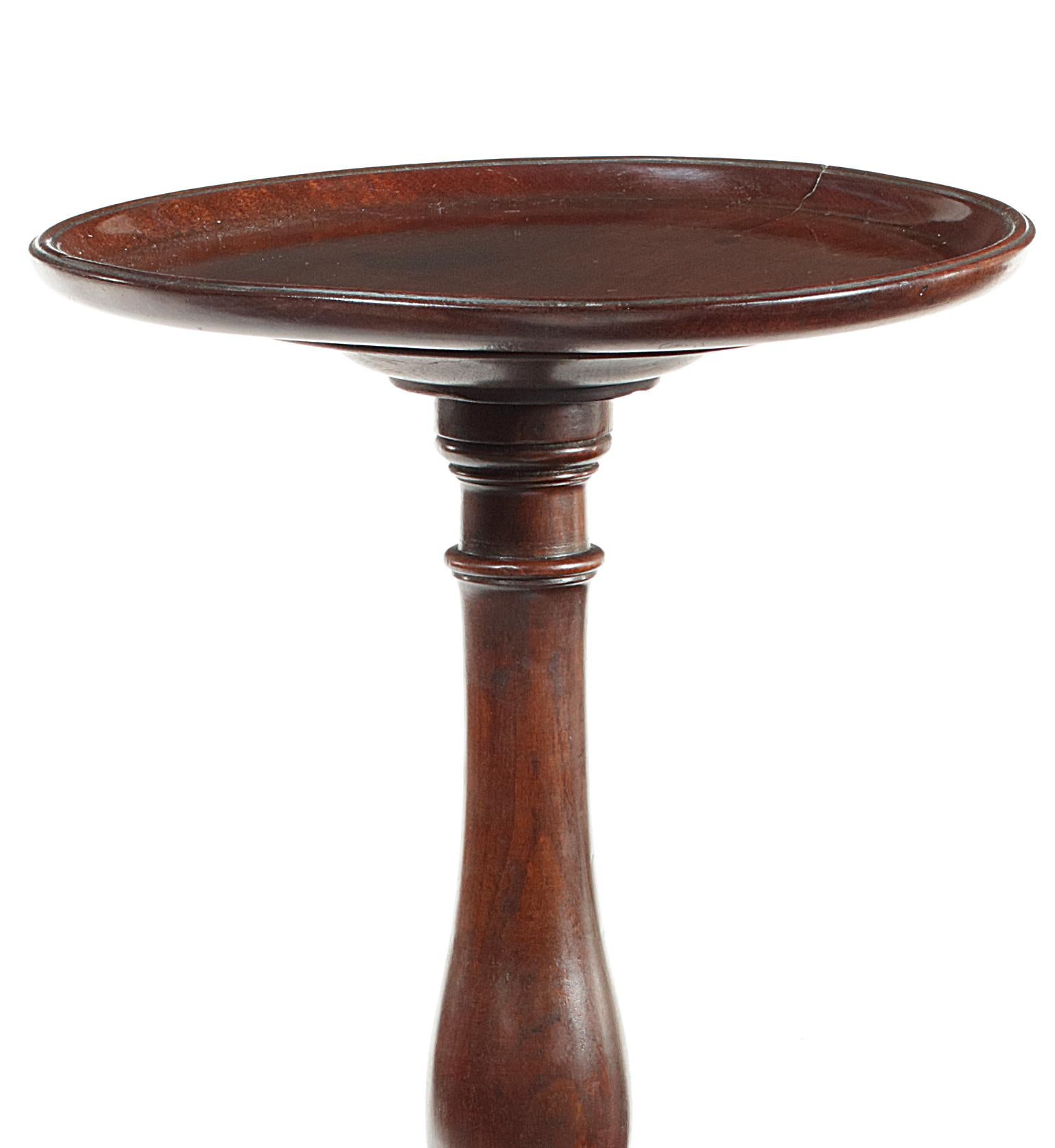 The circular dished top on a slender double baluster column and triform base with down swept legs and pad feet, measures: 31 cm diameter, 97 cm high.

  
