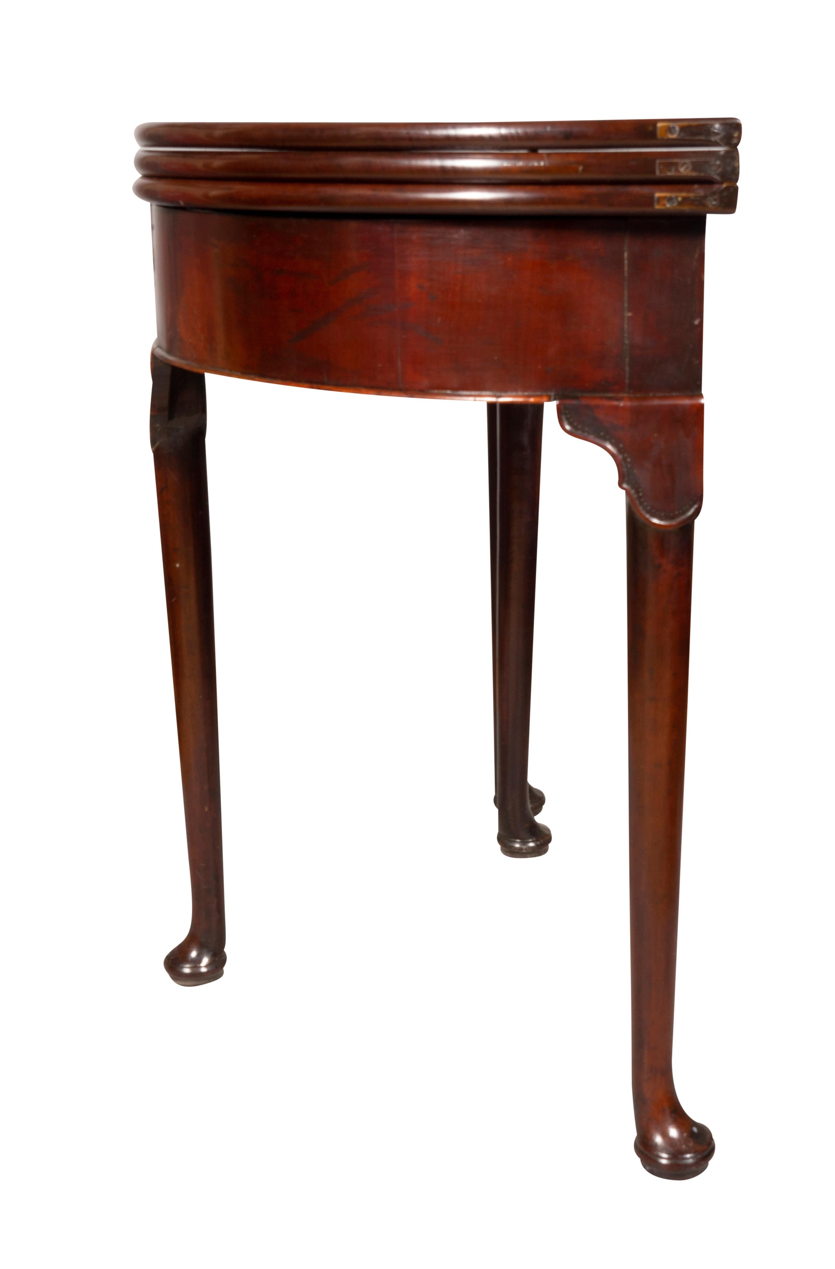 With triple top opening to a velvet playing surface. With interior well. Raised on circular tapered legs with carved lappet design at top of legs. Ending on pad feet.