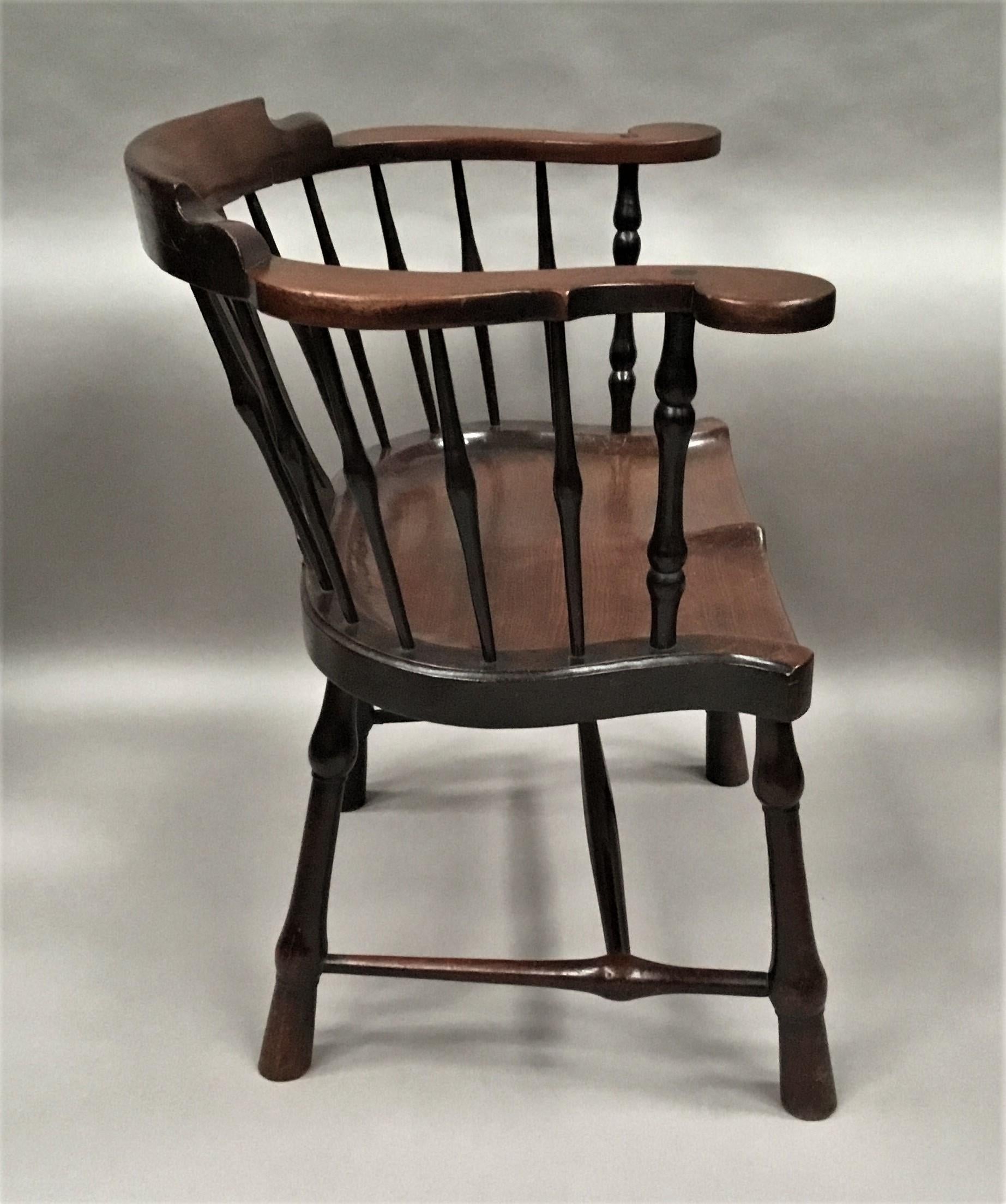 A good rare, George II mahogany windsor type armchair of very unusual form; the curved back with a raised shaped backrest on outwardly scrolled arms above the central pierced splat and turned spindle supports (the spindles unusually made of padouk