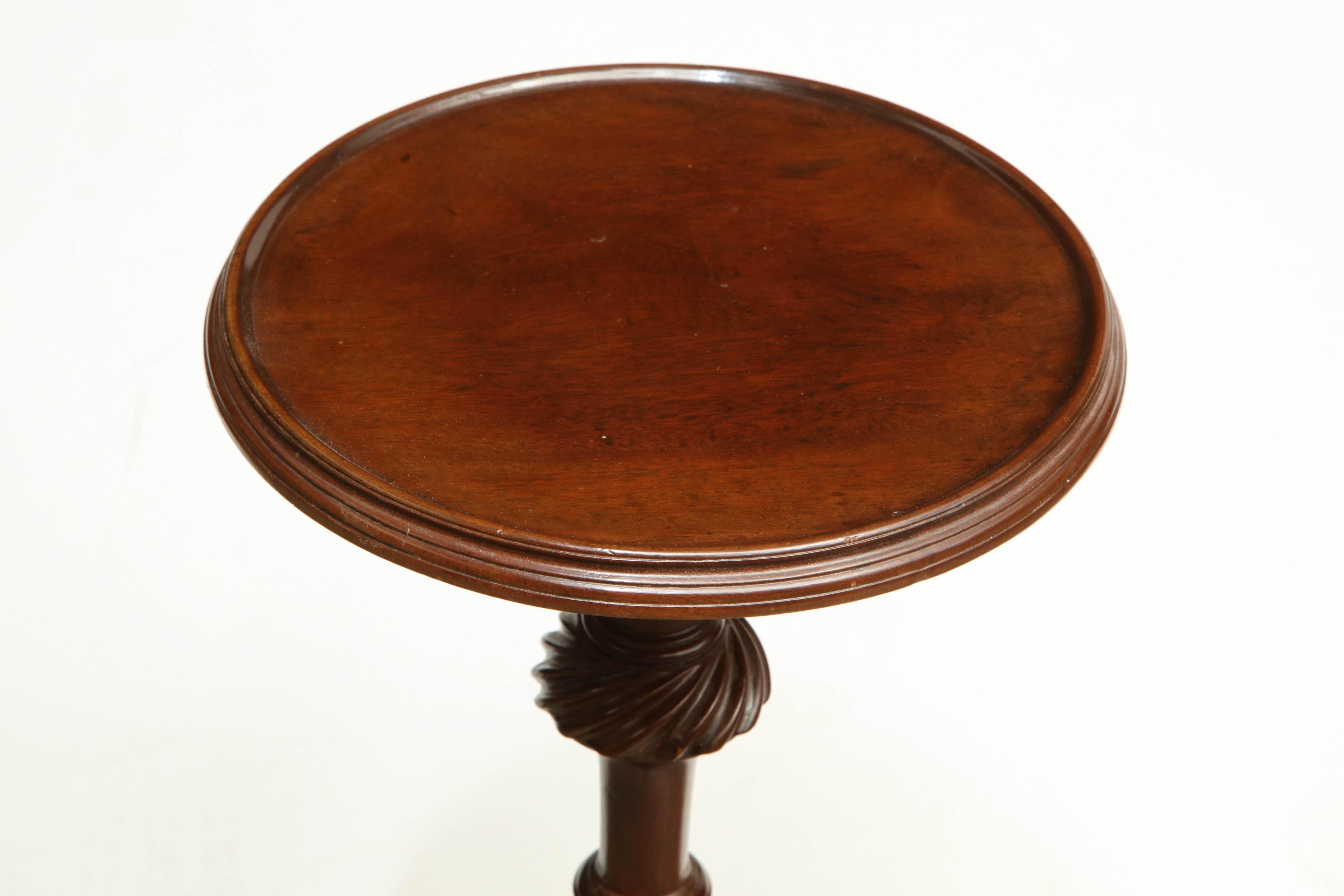 An English George II mahogany wine table with dished top and fluted urn form pedestal.