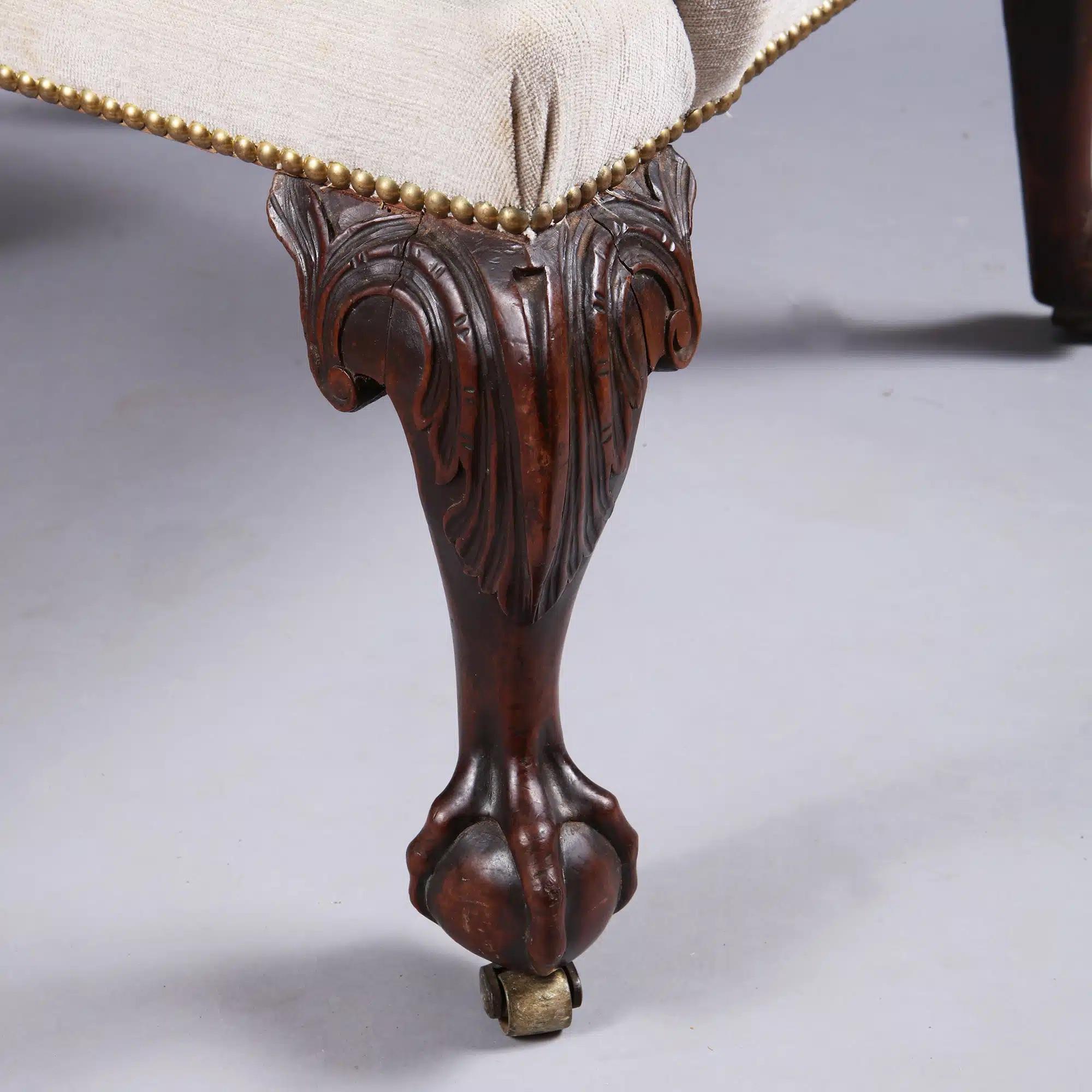 Dieser antike englische Ohrensessel stammt aus dem frühen 18. Jahrhundert aus der Zeit von George II. Er ist gepolstert und steht auf geschnitzten Mahagoni-Cabriole-Beinen mit geschnitzten Akanthusknien und Kugel- und Krallenfüßen. Für zusätzliche