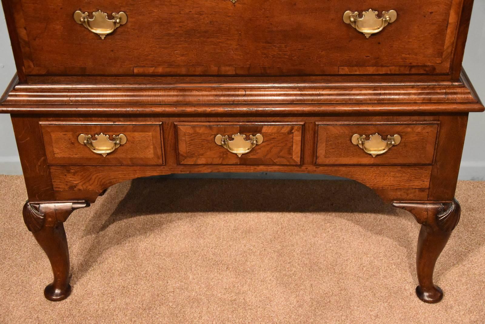 A George II oak chest on stand raised upon cabriole legs with walnut crossbanding

Dimensions
Height 61