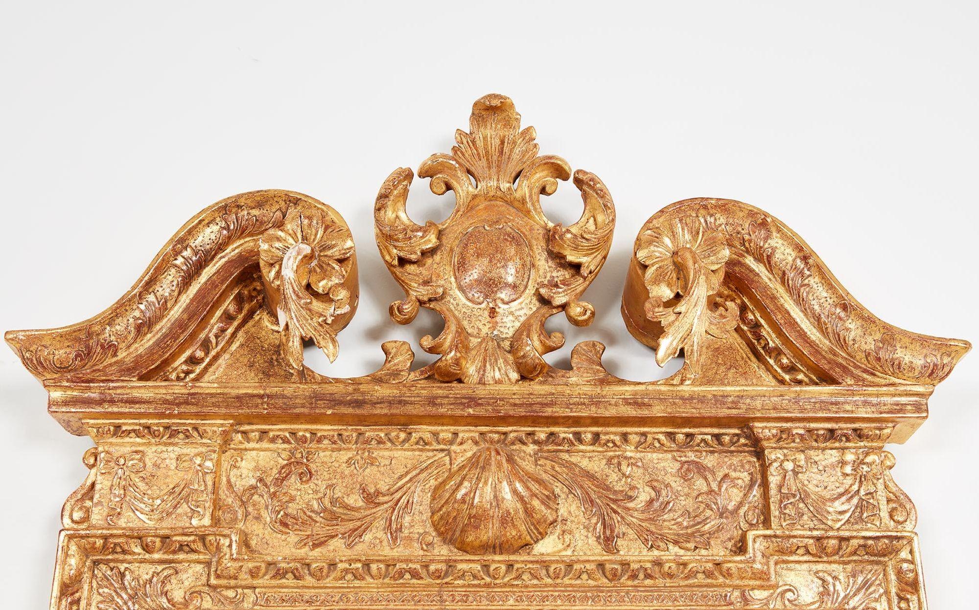 Fine George II gilt carved wood and gesso mirror, the central cartouche with cabochon carved center, flanked by scrolled pediment having foliate carving and egg and dart molded edge, the mercury glass plate housed within an egg and dart, foliate and