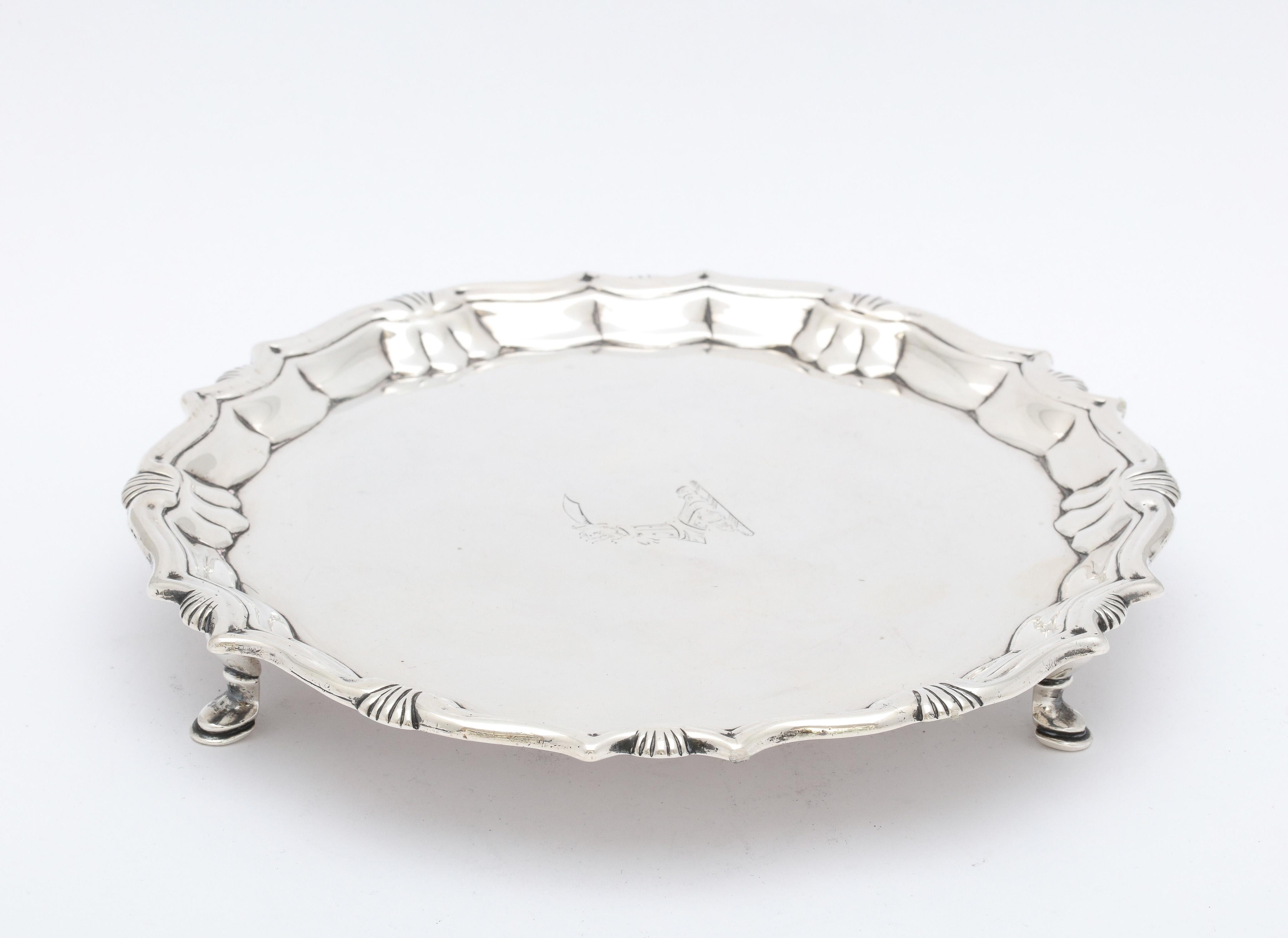 George II, sterling silver, footed salver/tray, London, year-hallmarked for 1744, Robert Abercromby - maker. Scalloped border. Salver has a central armorial of a raised arm in armor holding a scimitar. Measures almost 6 3/4 inches diameter x 1 inch