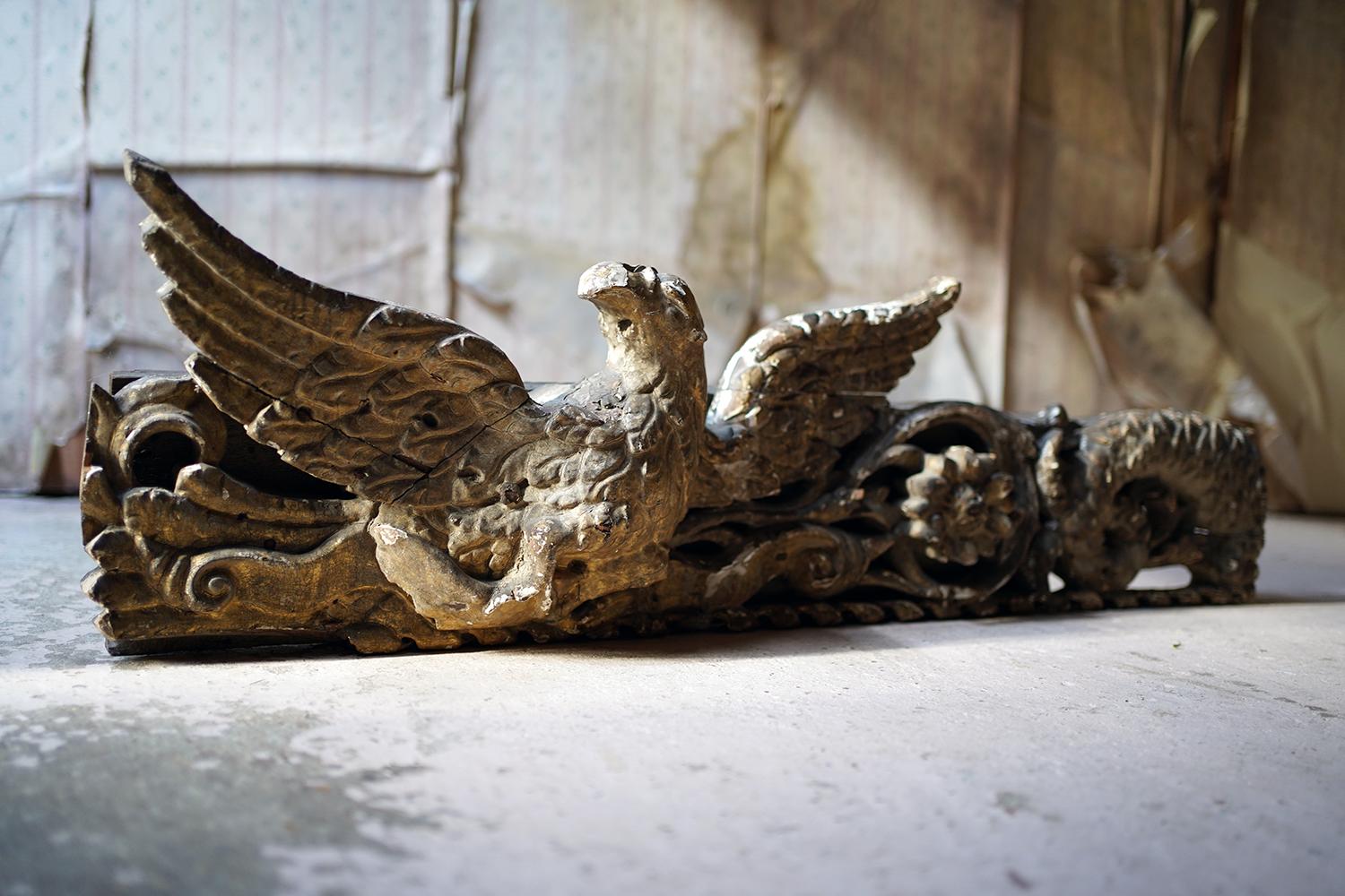 The giltwood and gesso hand carved fragment, still of good imposing size, having been part of a larger composition, showing a heraldic eagle amongst foliage and a large flower head to a scaled sea serpent all above a helix twist frieze, having