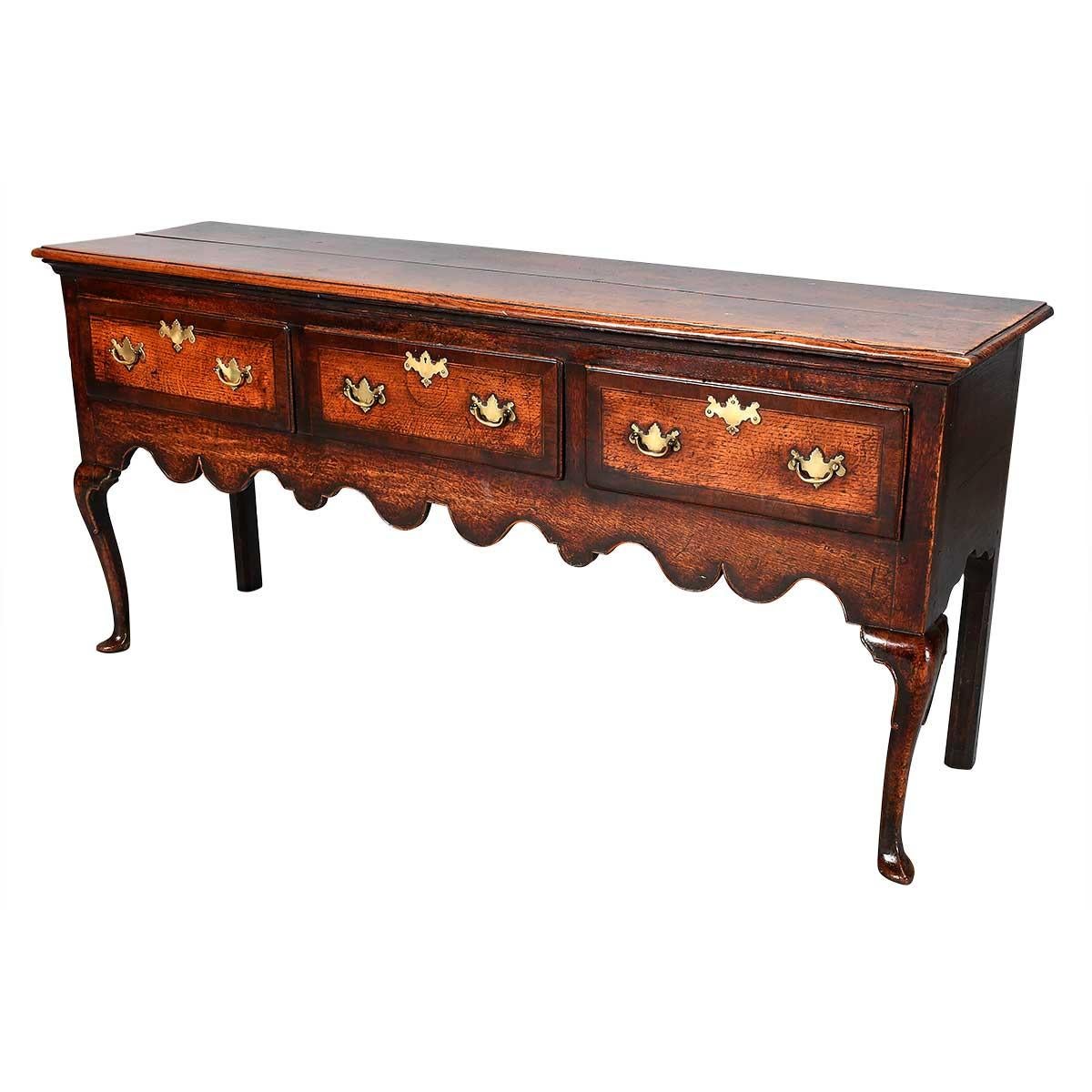 A fine quality oak dresser standing on cabriole legs. The scallop-shaped apron is accentuated with cock-beading. The three drawers are cross-banded in mahogany. English or possibly Welsh. Retaining an extraordinary color and patina. Hardware later.