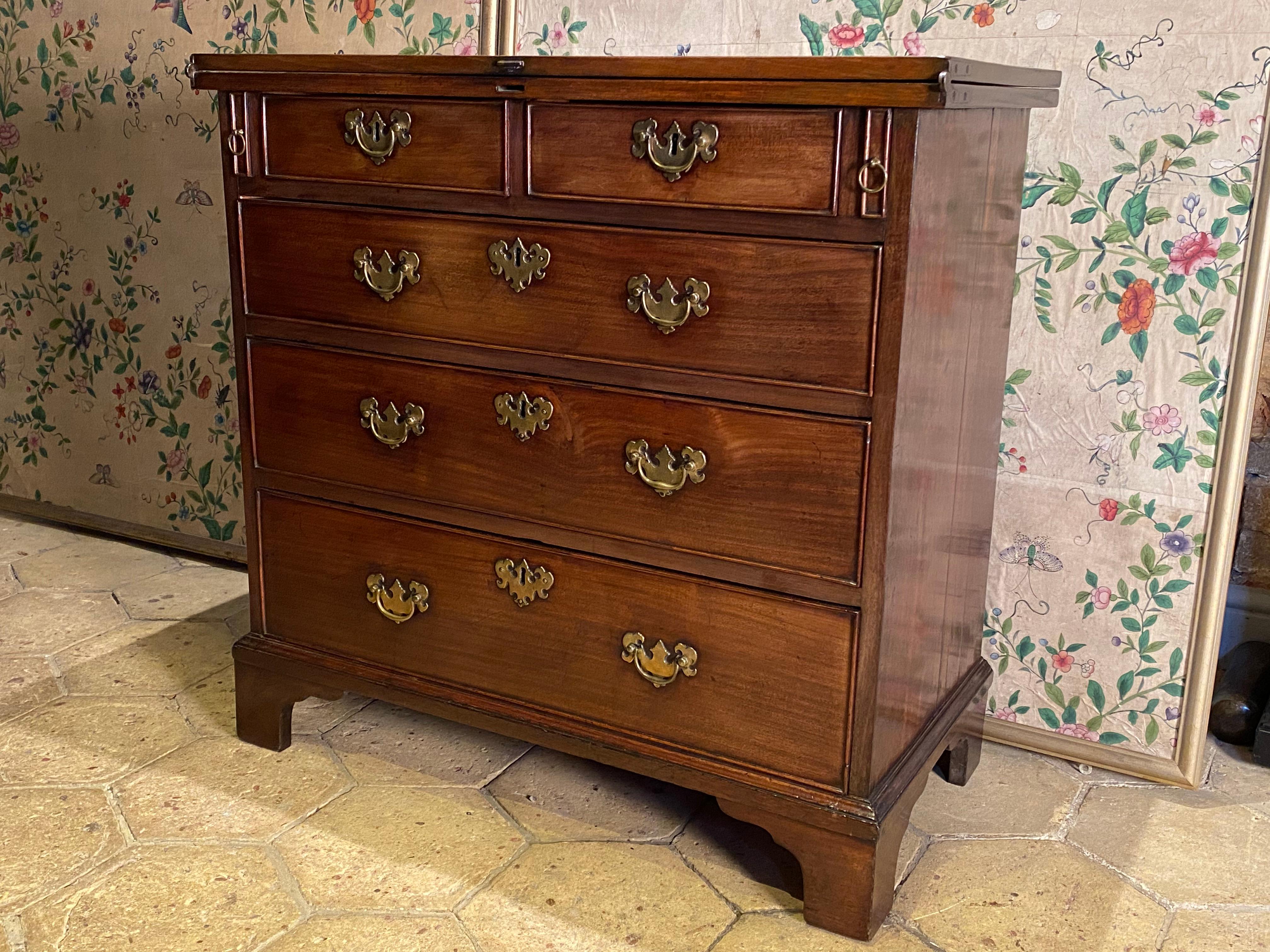 A small English George II period mahogany fold-over top bachelor's chest, circa 1750.
Of good rich color and old patination.

This small Georgian - mid 18th century - bachelor’s chest is in solid mahogany.
With two short and three long drawers.