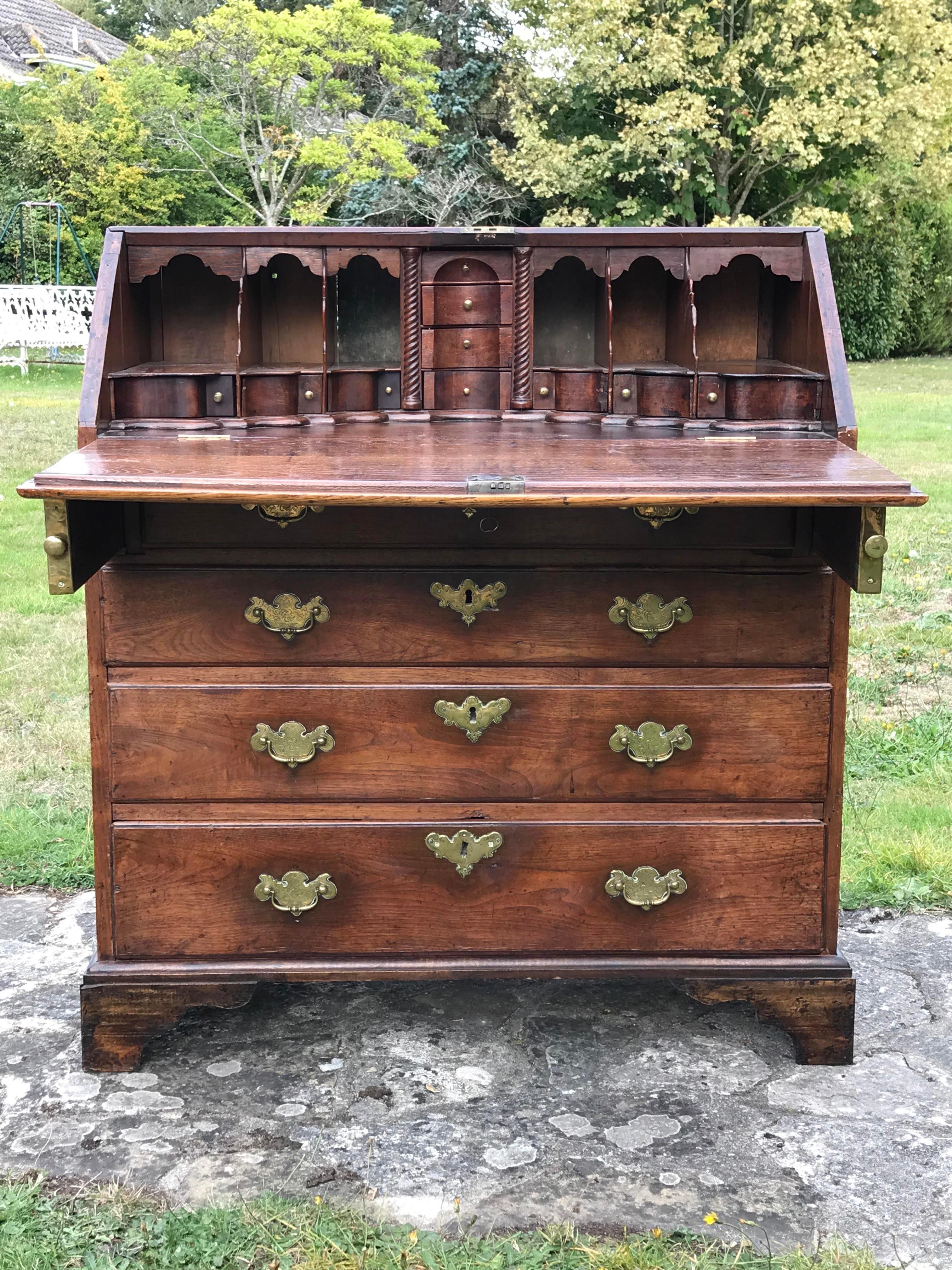 A solid walnut Georgian bureau. 
George II period, circa 1740.

This 18th-century walnut bureau retains its original engraved mounts.
Of good rich color and old patina.

It has a remarkable multi-serpentine and concave fitted interior of numerous