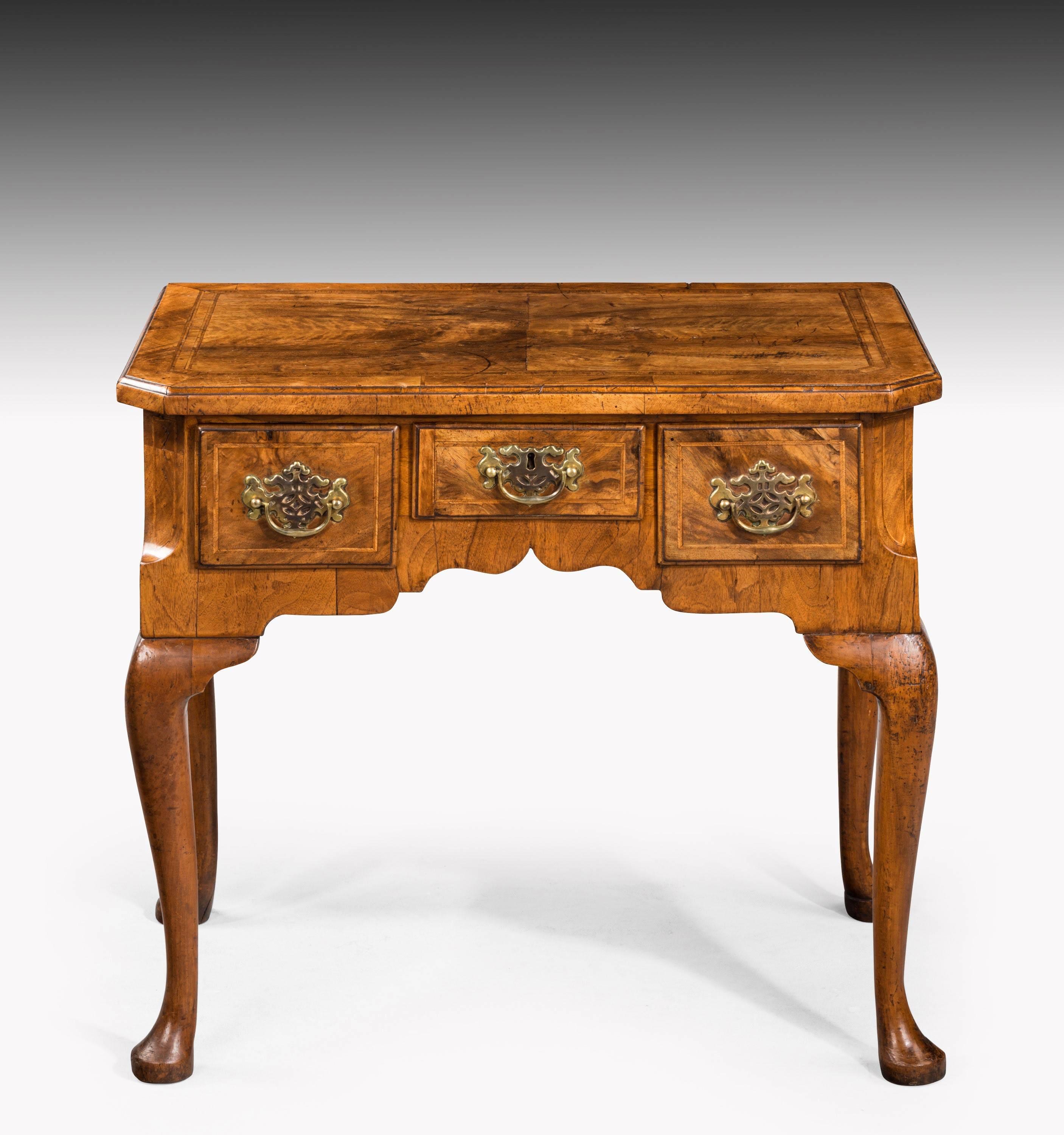 A fine early George II period walnut lowboy of quite exceptionally figured timbers matching throughout. The top double banded in herringbone and with contrasting borders. Cabriole supports. Fine overall condition and with cantered corners.
