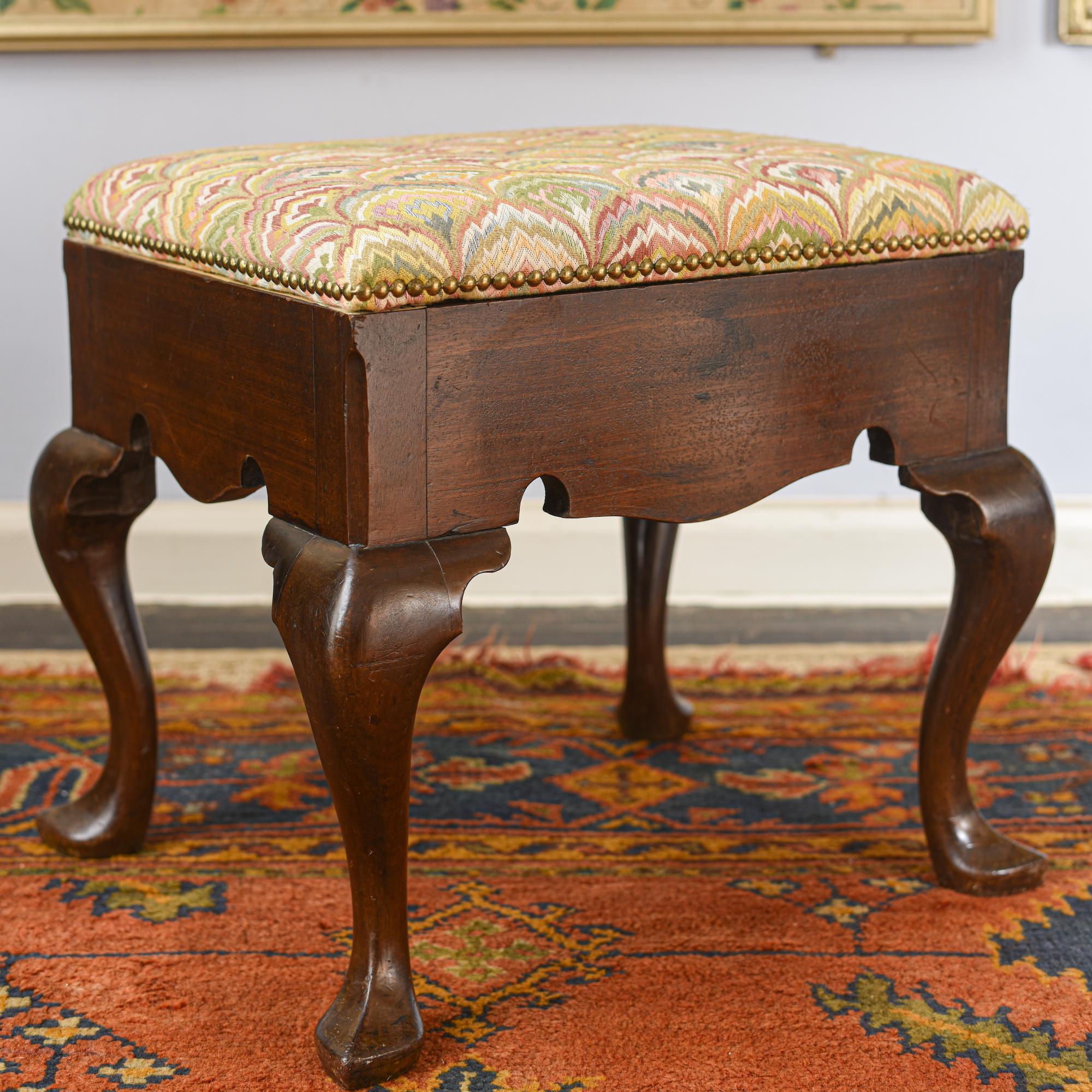 A good quality George II-period Virginia (or 'red') walnut stool with a shaped apron.
Mid-18th century, circa 1750.
Excellent overall color and patination.

The rising top close-nailed in ‘pointe de Hongrie’ type fabric, and revealing a recess.
The