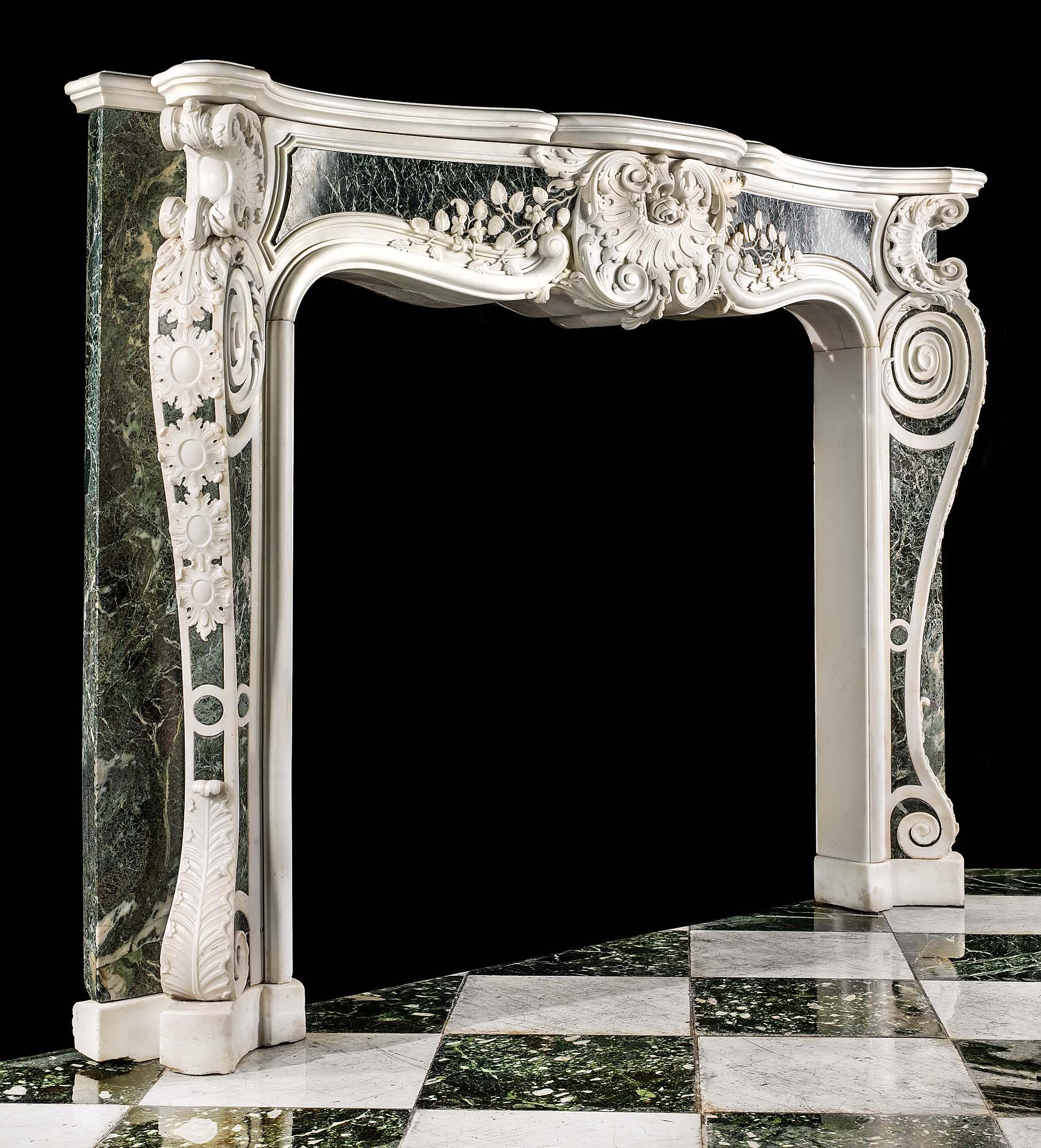 Ein großer, seltener und imposanter englischer Rokokokamin aus dem späten George II. mit starken palladianischen Einflüssen, geschnitzt aus weißem, statuarischem Marmor und eingelegt in Platten aus Verde Antico-Marmor. In der Mitte des getäfelten