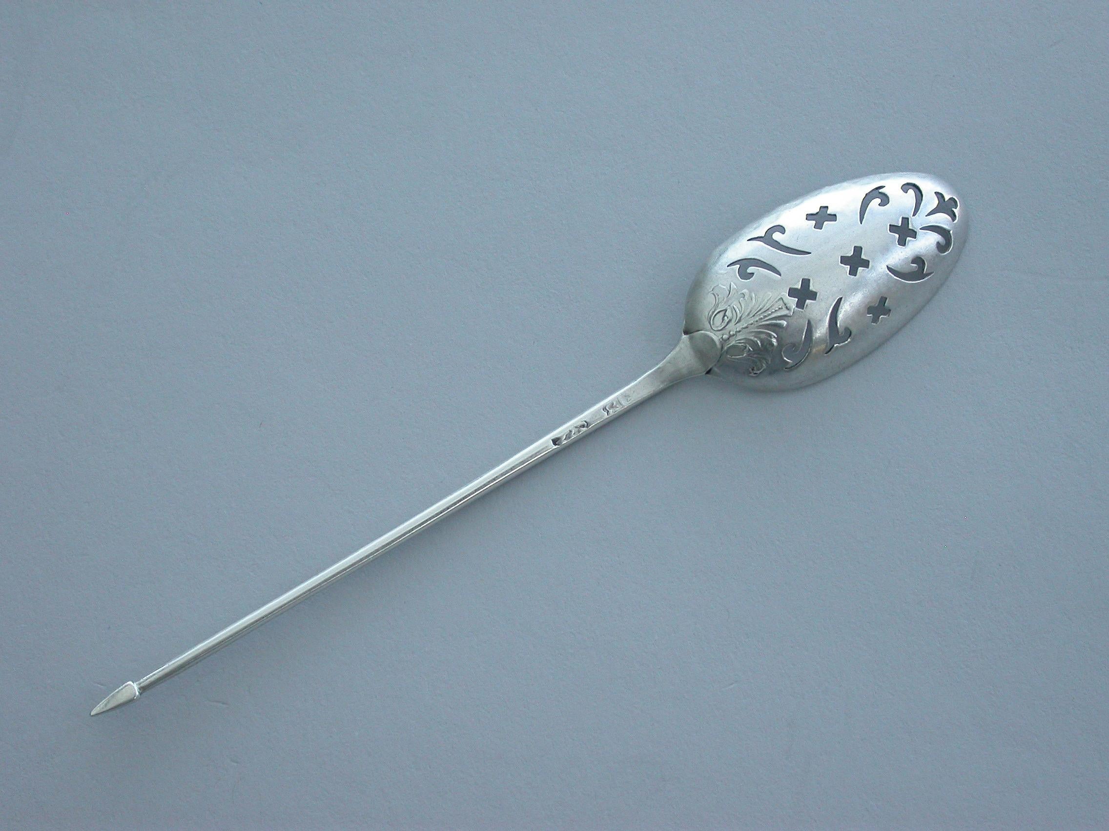 A fine George II 'Fancy-back' silver mote spoon, the plain tapering handle terminating with a diamond point finial, the oval bowl pierced with scrolls crosslets and a fleur-de-lys and chased with an anthemion type shell in the Rococo style.

By
