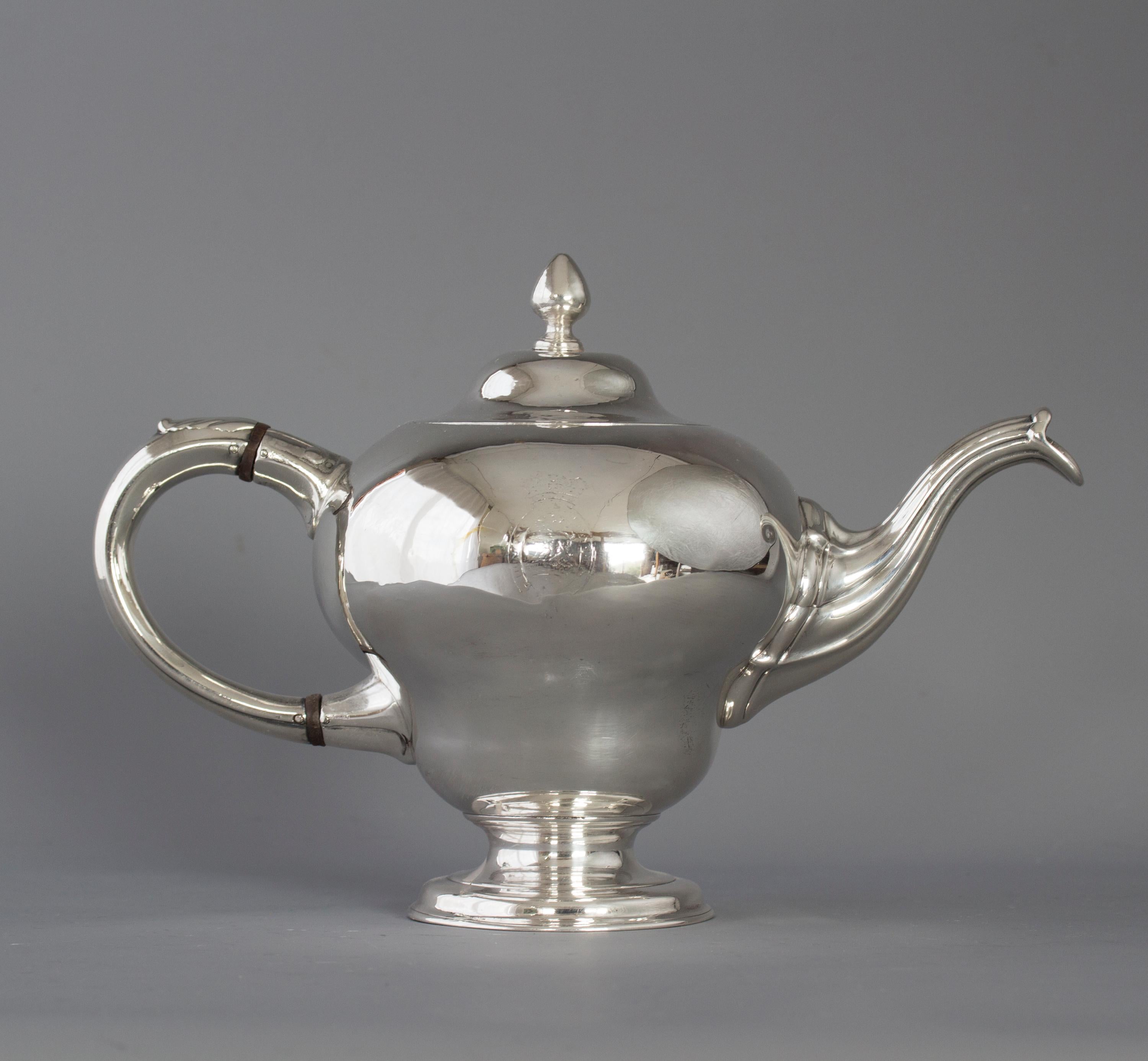 A rare and superb George II Scottish silver teapot, Edinburgh 1749 by Edward Lothian. The body is raised in the inverted pear-shaped form, plain except for a crest and motto to each side – see pictures. A cast, tapering and gadrooned spout. The