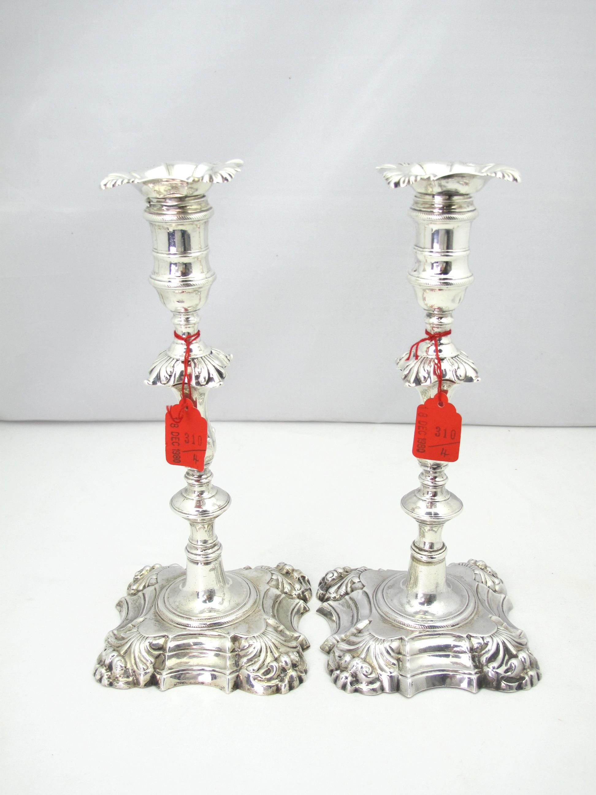 An excellent pair of George II silver candlesticks by John Cafe at London 1752. These candlesticks are finely cast on square stepped base with foliate corners, baluster shape with lovely quadrefoil blossom at center, complete with original drip