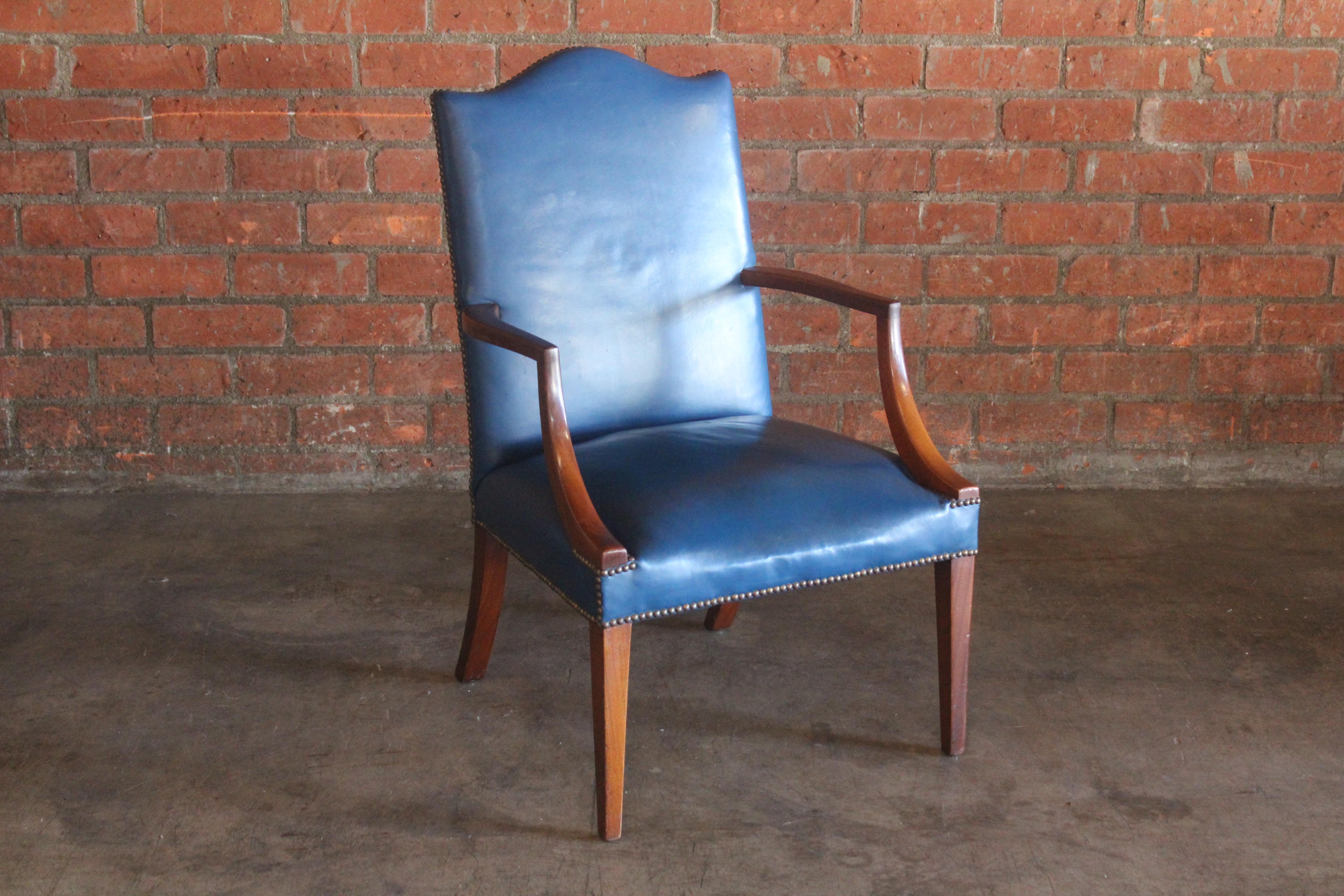 A vintage 1920s George II style armchair in mahogany and blue leather. It was upholstered in 1975. Features brass nailheads. In good condition with some wear to both the leather and wood.