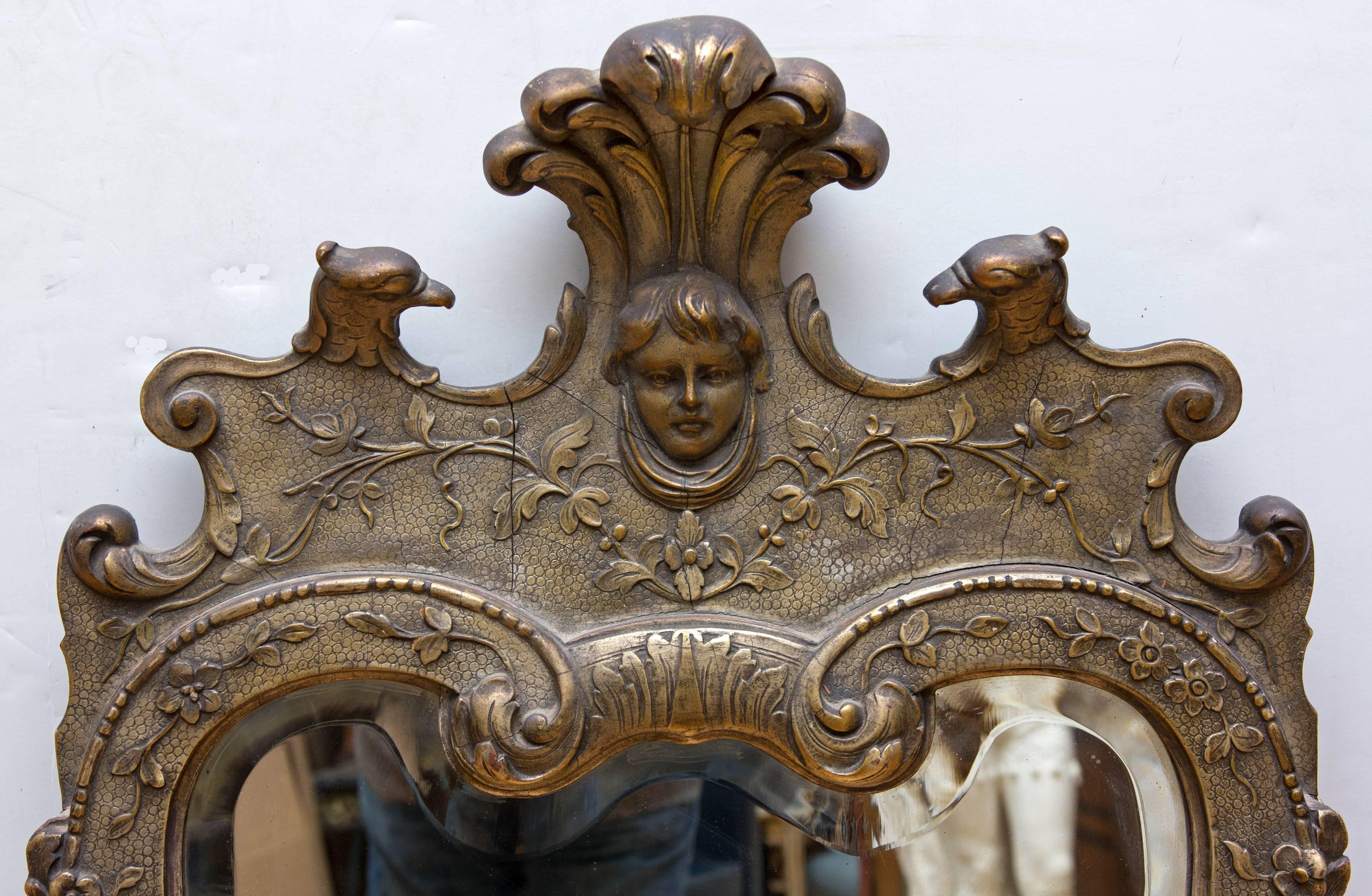 Antique George II revival silver gilt console mirror. Carved wood and gesso decoration. Mirror is beveled and original, circa 1920s.