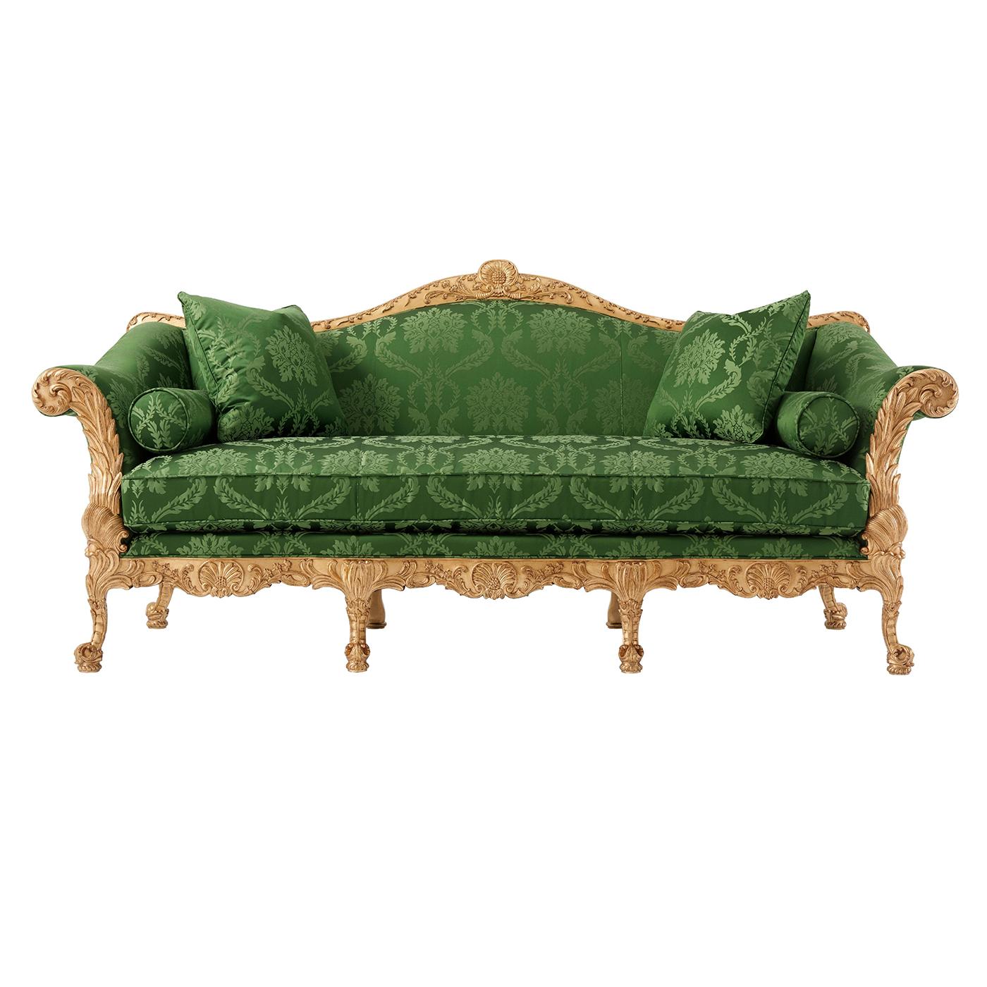 An elaborate George II style hand carved mahogany and gilt sofa, the arched top rail above a tight back and down swept arms, the bench seat with two bolster cushions and two throw pillows, with palm-leaf carved out swept arms and rails above