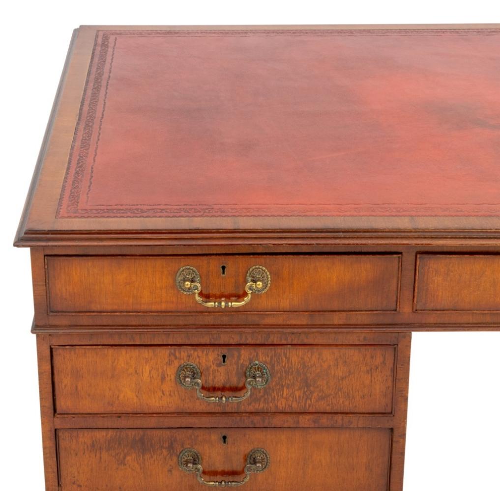 George II Style Leather Top Walnut Desk, 20th century, with red leather inset writing surface, three frieze drawers above two pedestals each with three graduated drawers on four bracket feet. 30