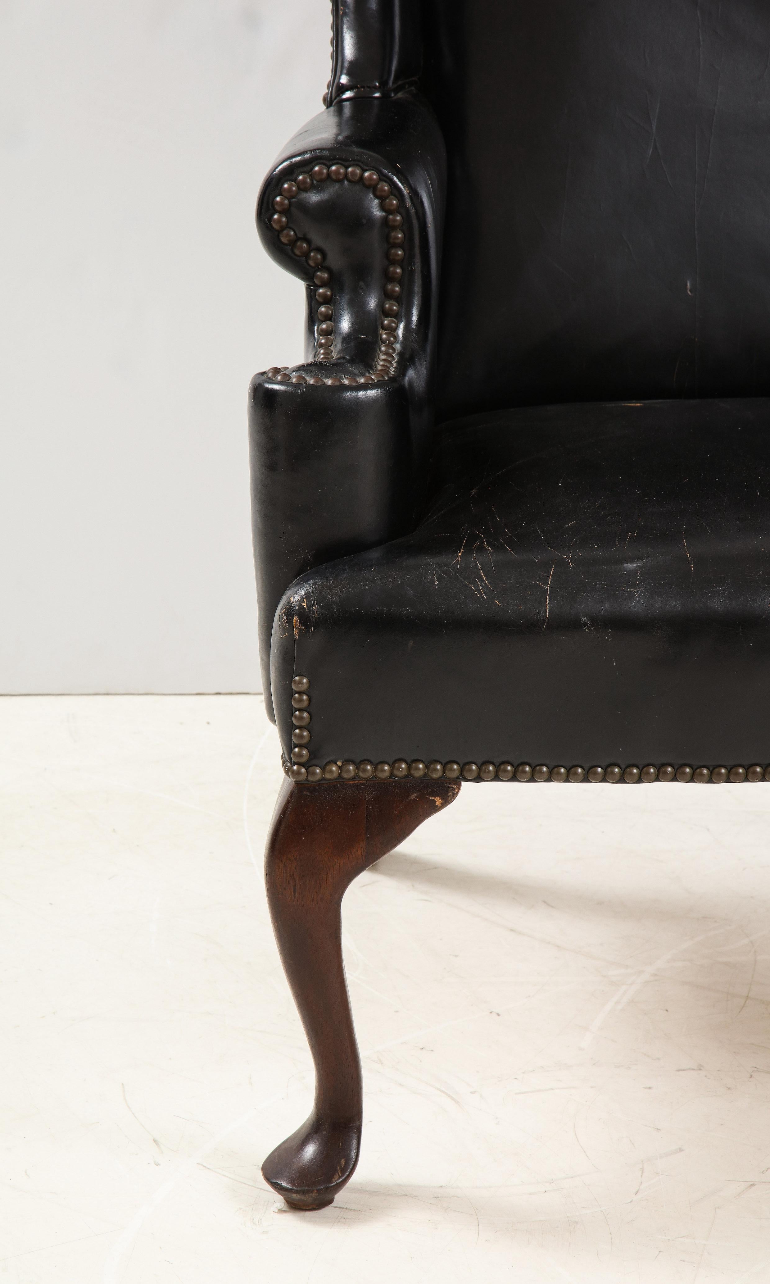 George II style mahogany and black leather upholstered wing chair.
Angleterre: circa 1900.
